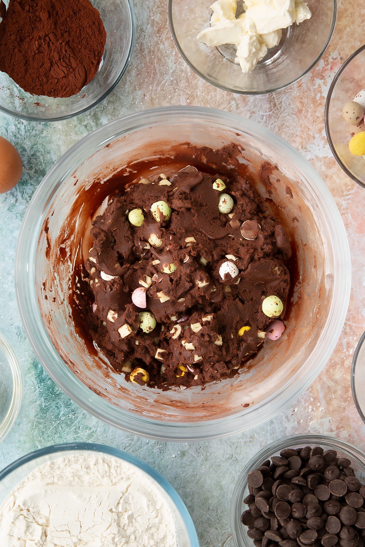 Overhead shot after the mini eggs have been mixed into the Easter cheesecake cookie mixture bowl.