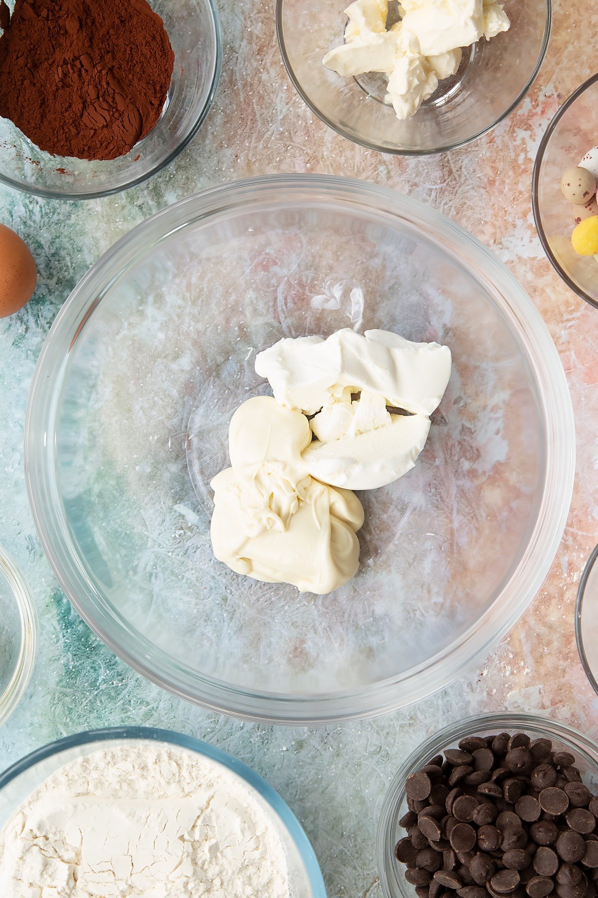 Melted white chocolate and cream cheese in a mixing bowl.