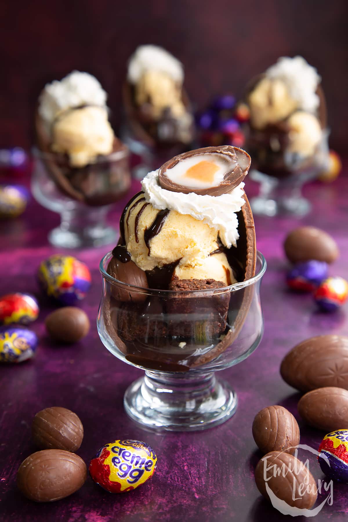 Half a creme egg being added ontop of the whipped cream on the Easter egg sundae.