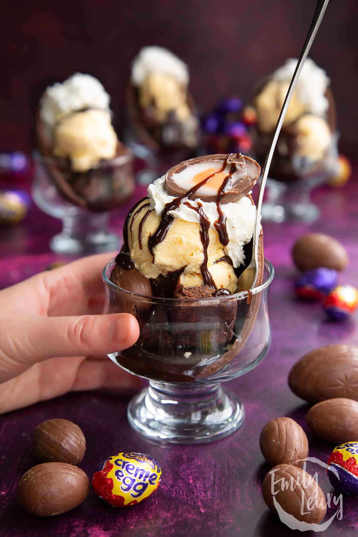 Hand reaching in to grab a finished Easter egg sundae