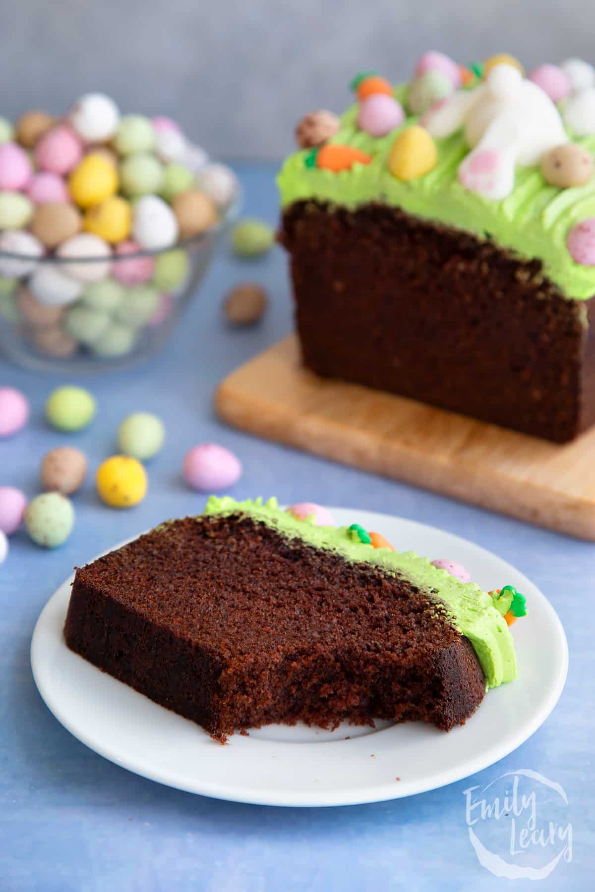 Slice of Easter loaf cake with a bite taken out served on a white plate.