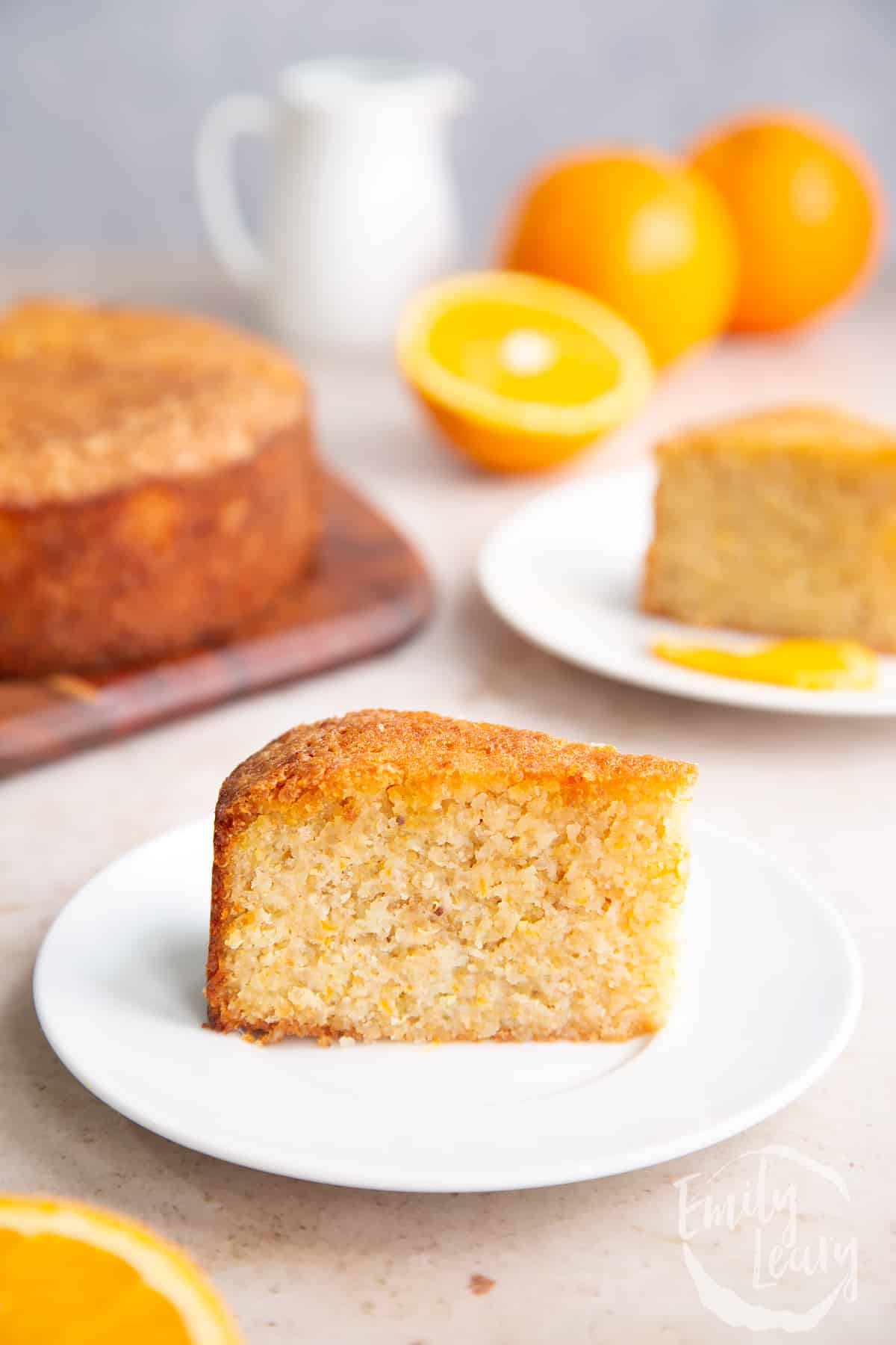 Orange cake cut into slices and served on a white plate.