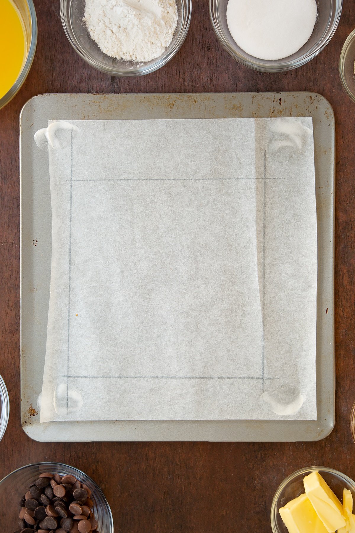 Overhead shot of baking paper with pencil markings using a ruler.