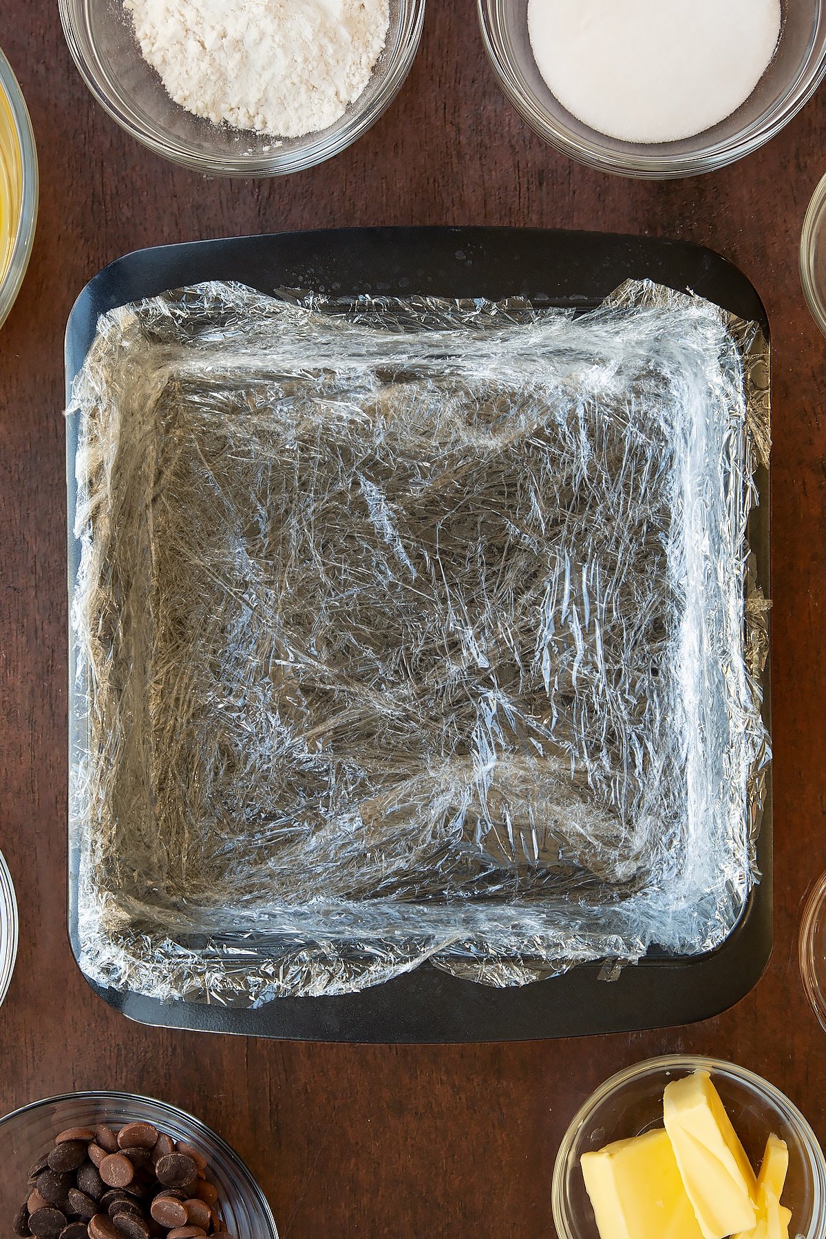 Square baking tin lined with cling film. 