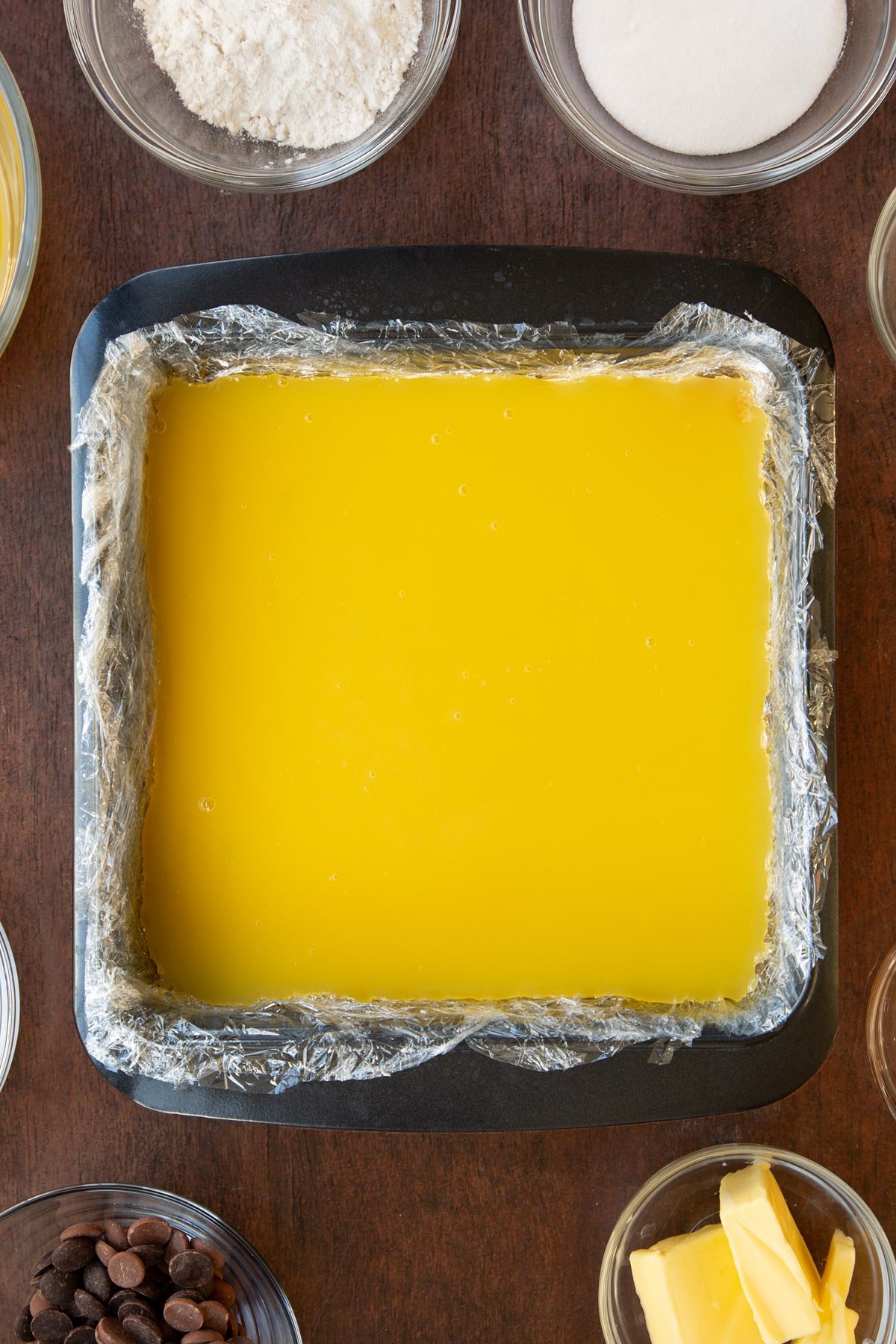 Pouring the orange juice geletine mixture into the baking tray and leaving to cool until it's just at the point of setting.