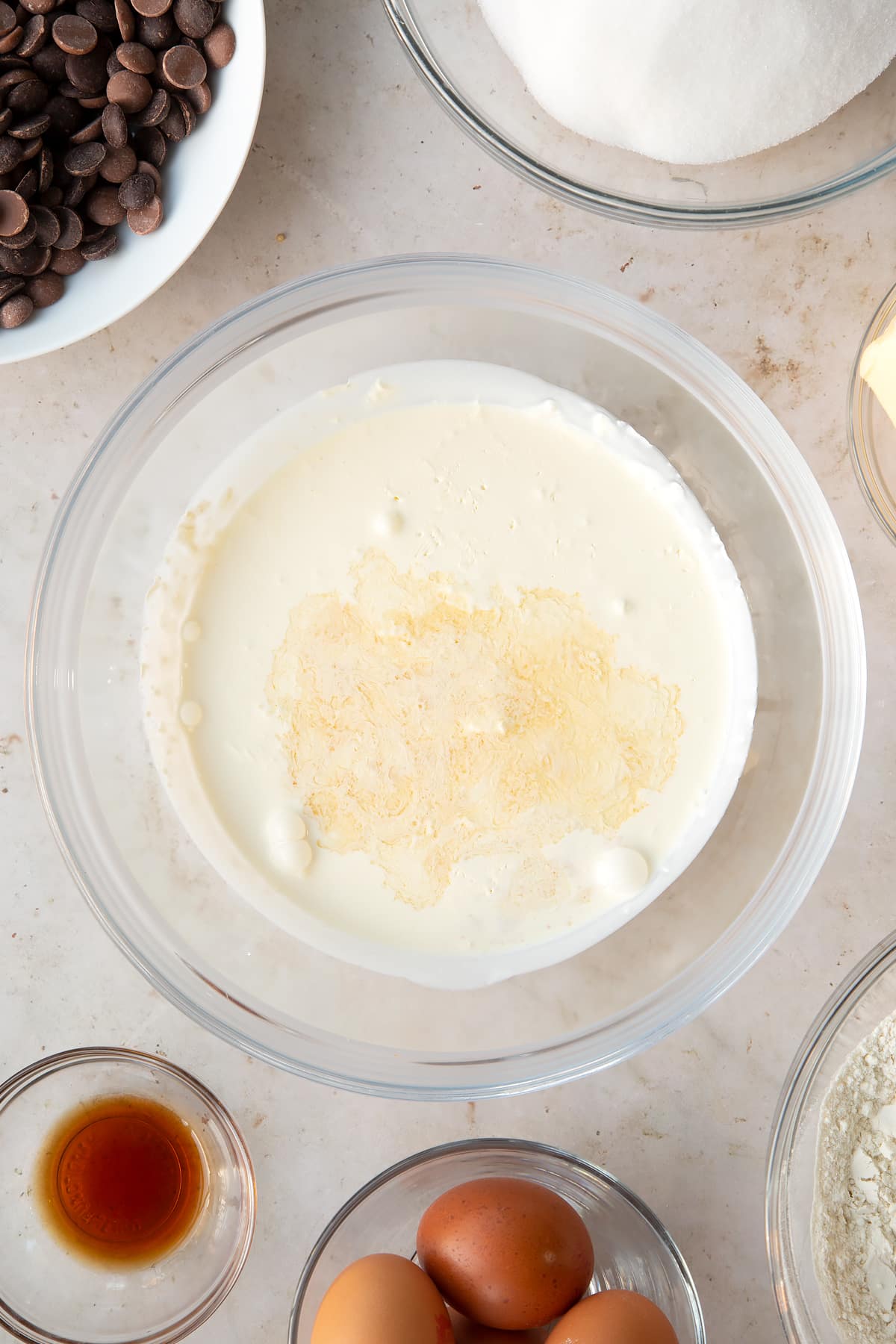 cream and vanilla in a heatproof bowl surrounded by ingredients.