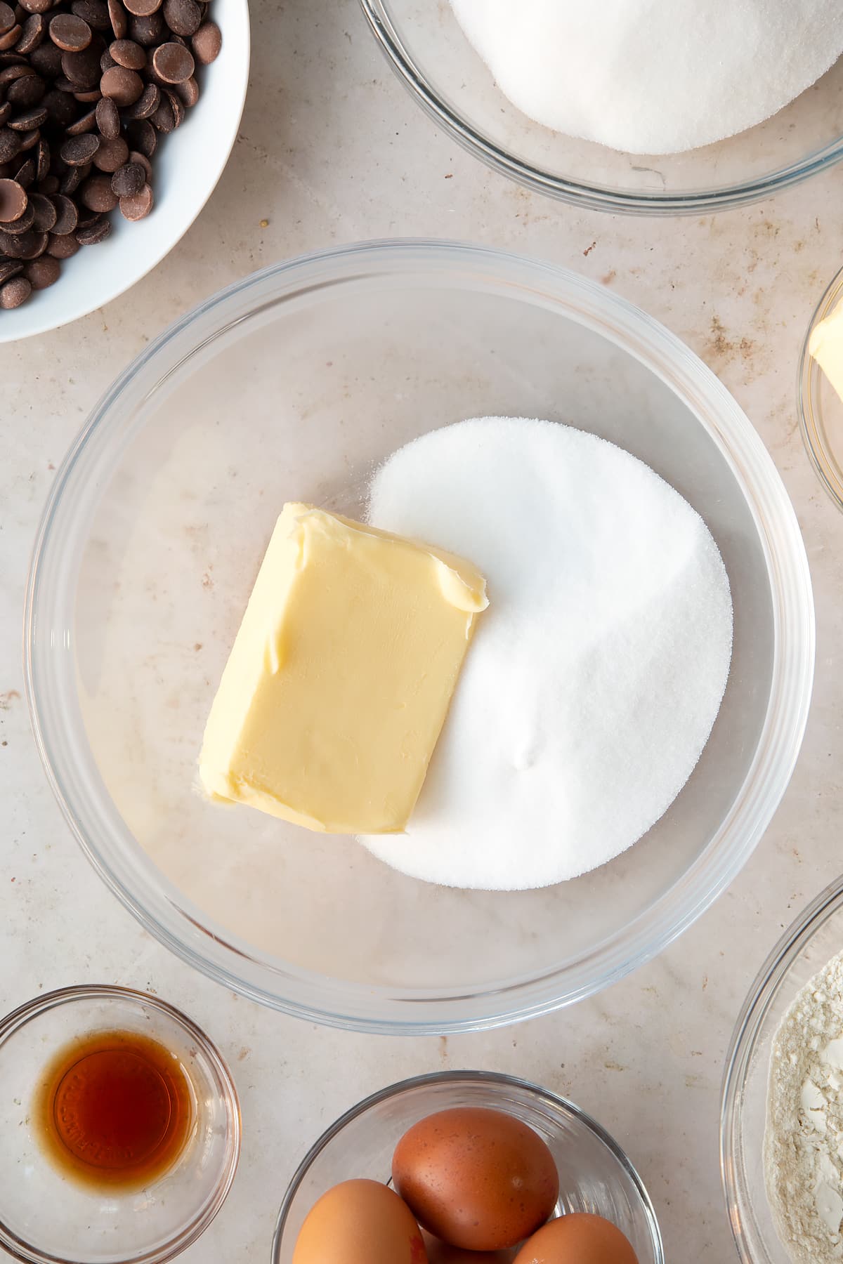 butter and white sugar in a large clear bowl surrounded by ingredients.