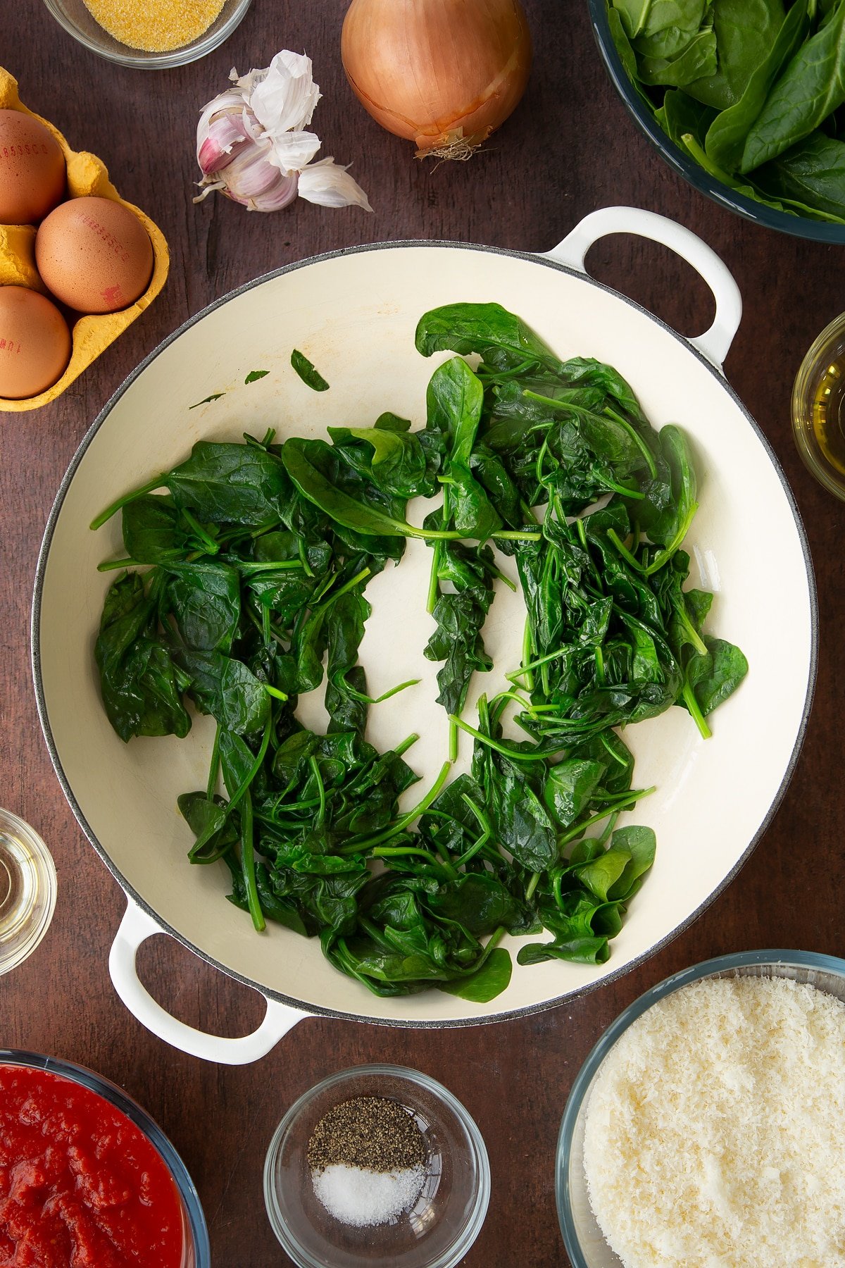 Overhead shot of spinach leaves after being cooked on a low heat in the pan.