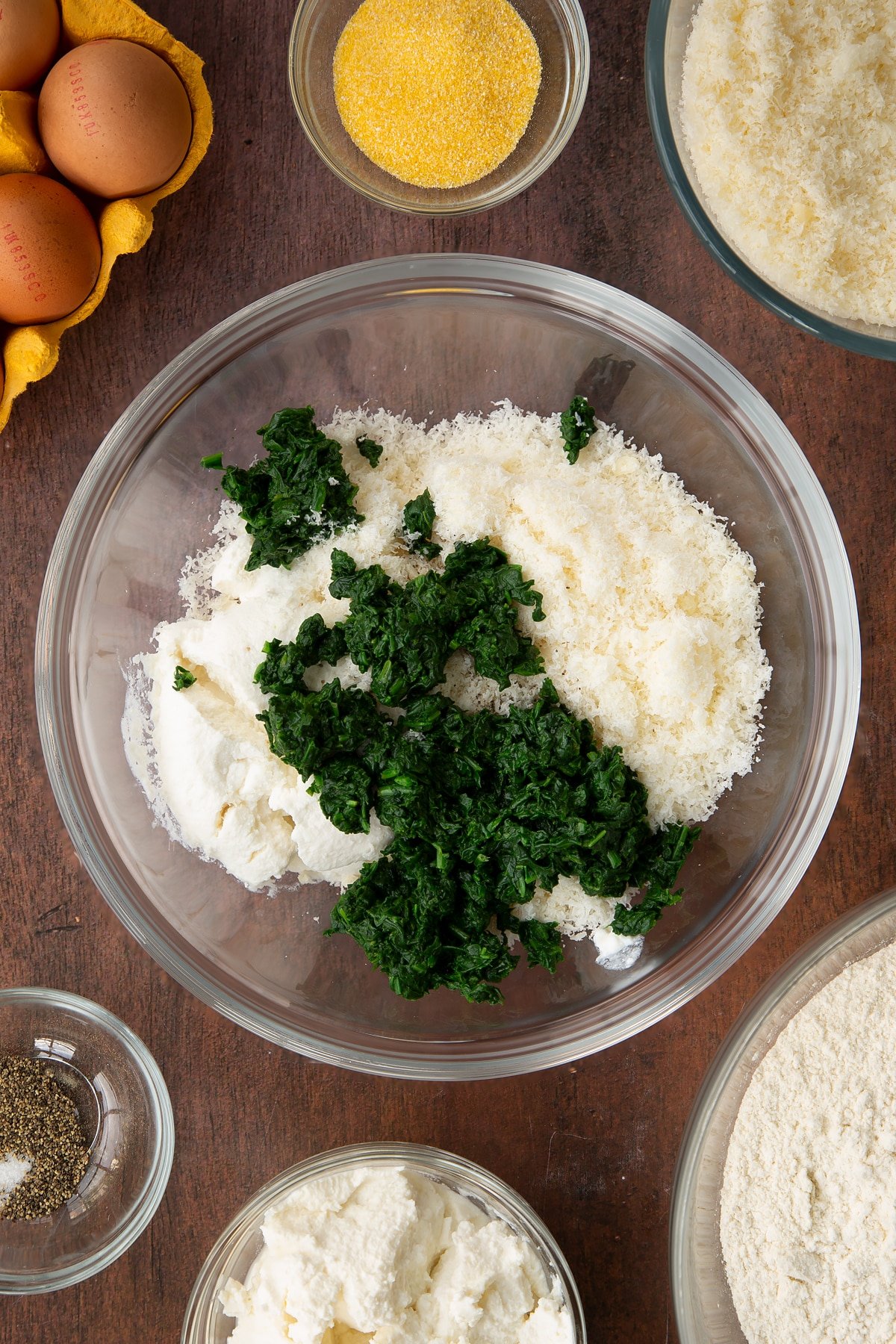 Adding the chopped spinach to the bowl of ingredients. 