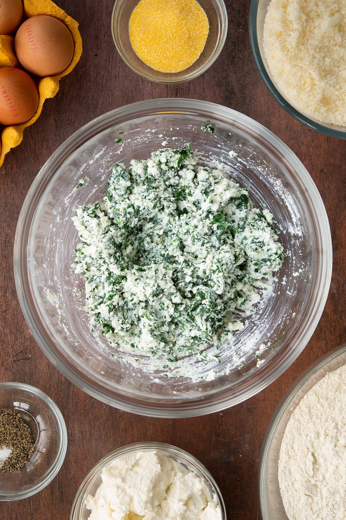 Overhead shot of the bowl having stirred the chopped spinach into the mixture.