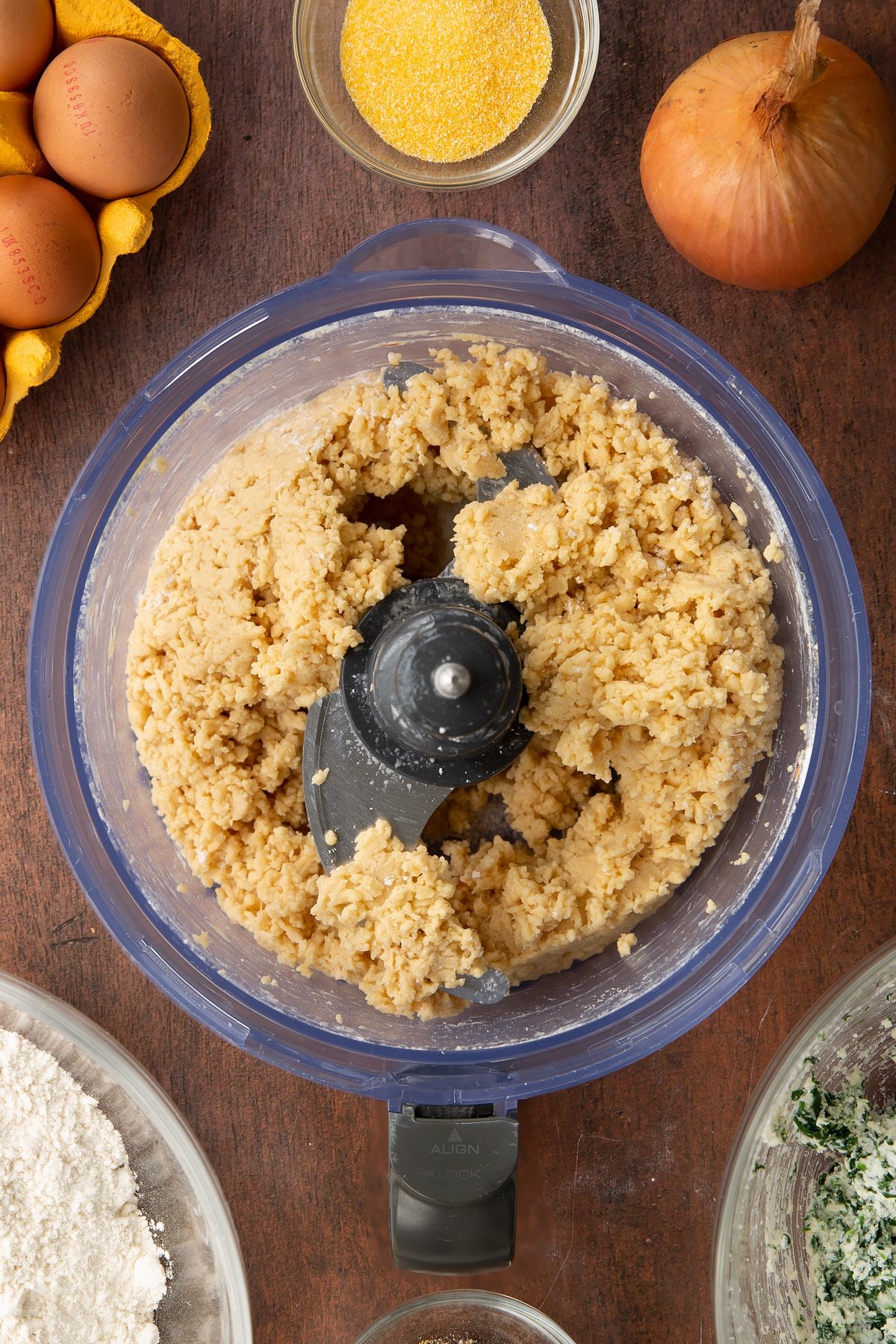 Overhead shot of the food processor having added eggs to the flour and mixed.