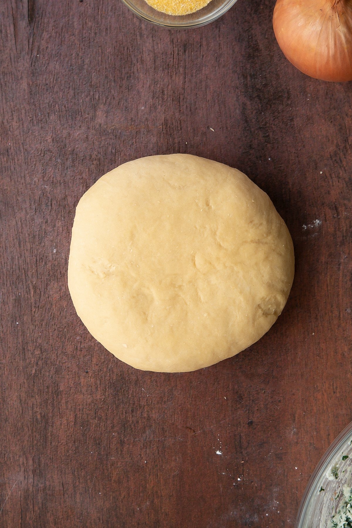 Overhead shot of the pasta dough on a wooden surface.