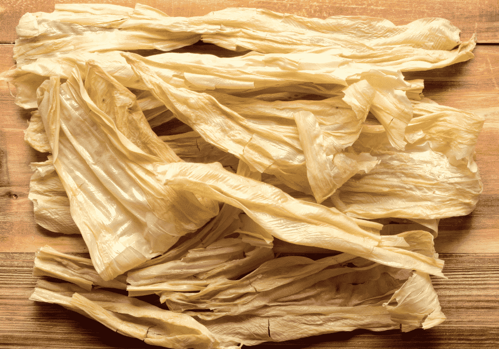 tofu strips piled onto a wooden board.