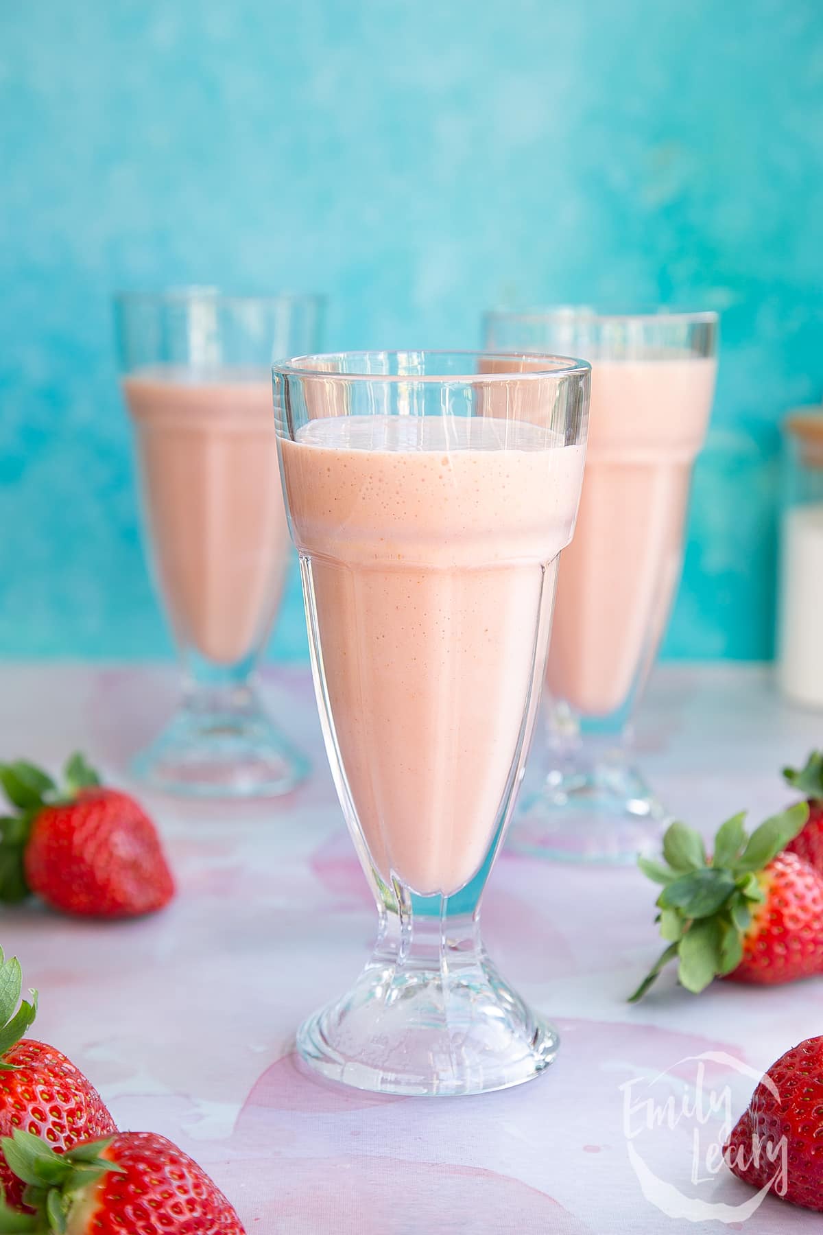 Three glasses of ice cream strawberry milkshake.