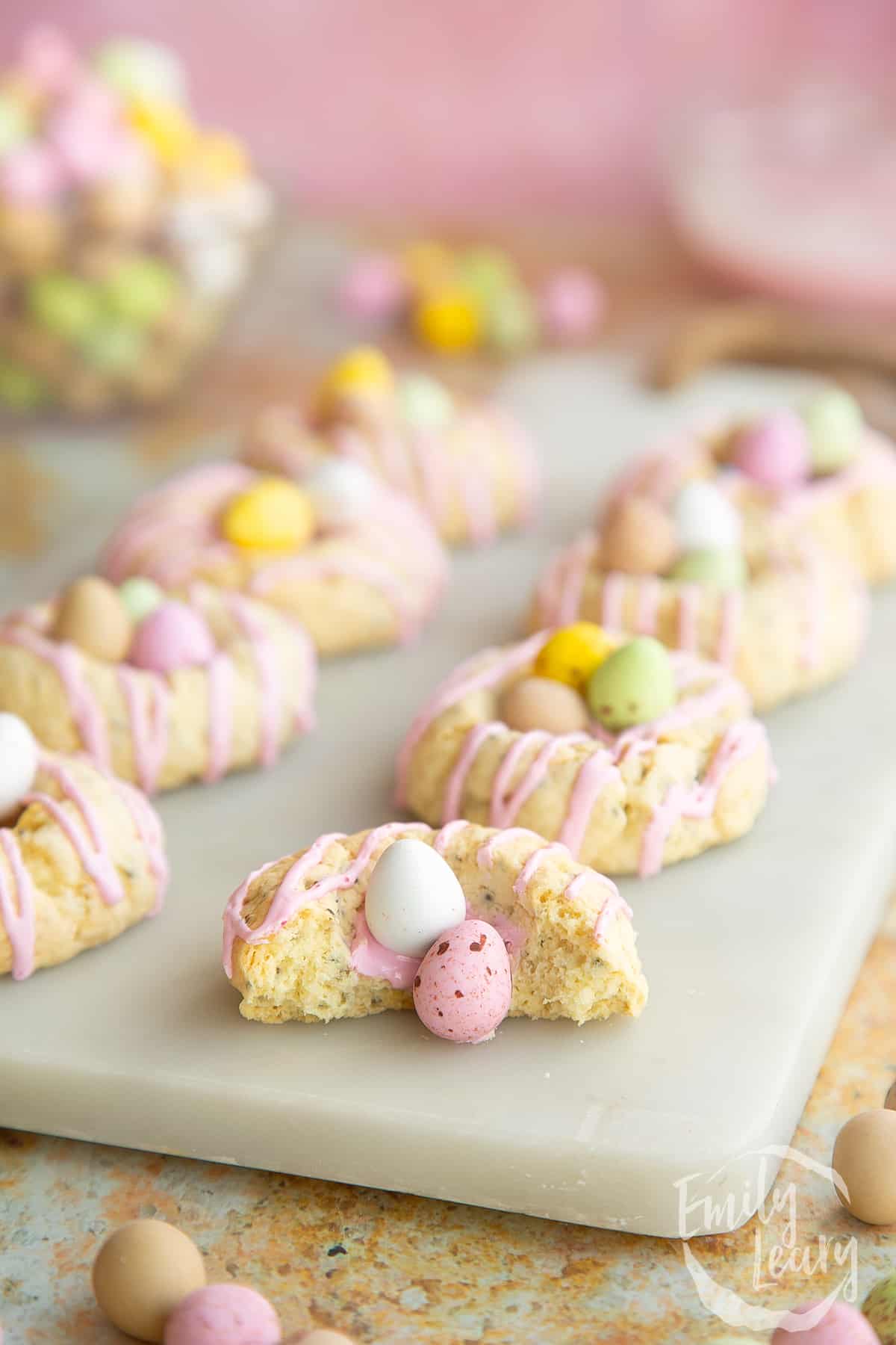 Close up shot of the finished vegan, gluten free easter biscuits on a marble board with one of the biscuits cut open.