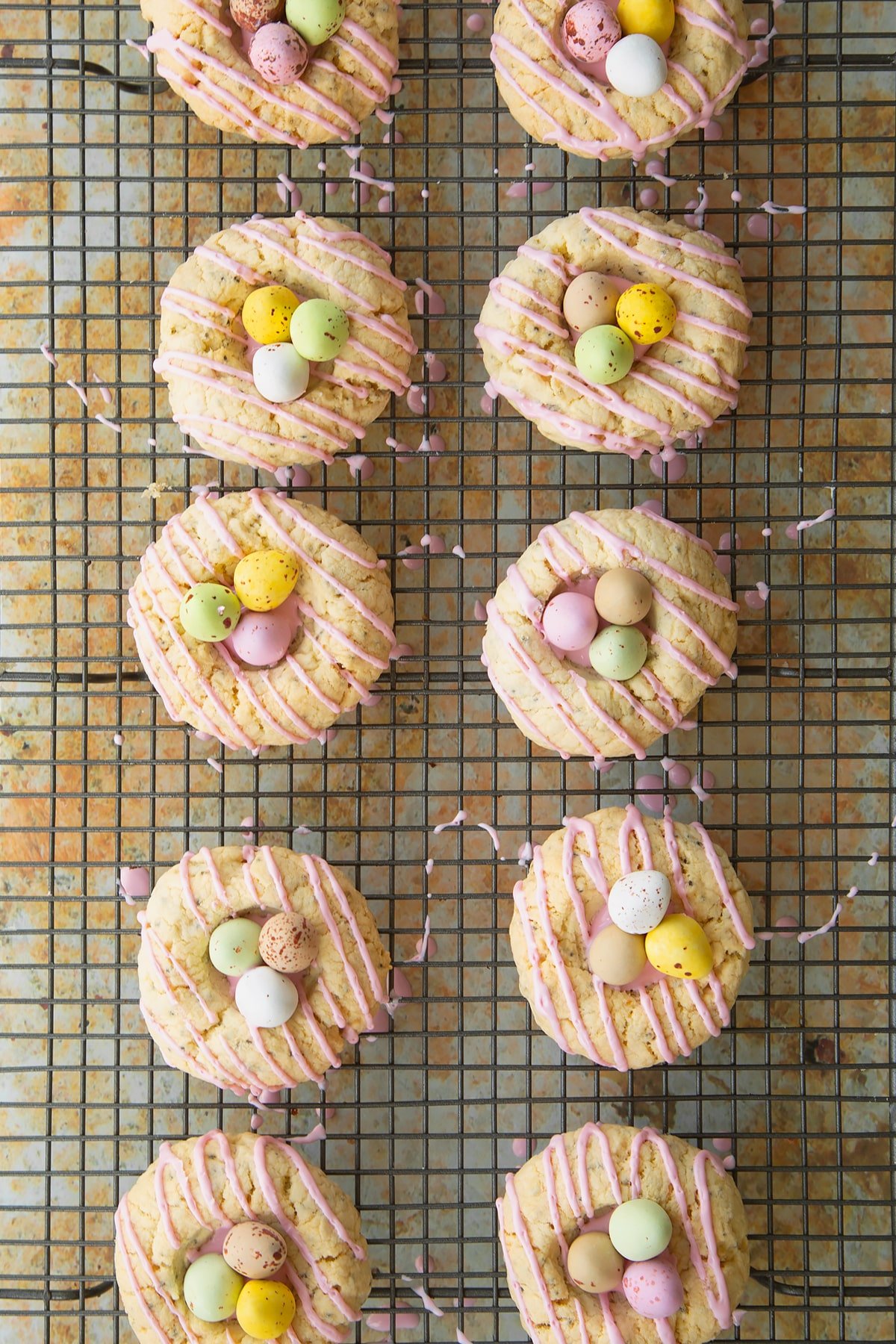 Adding the mini eggs ontop of the icing sugar in the well of the cookies.