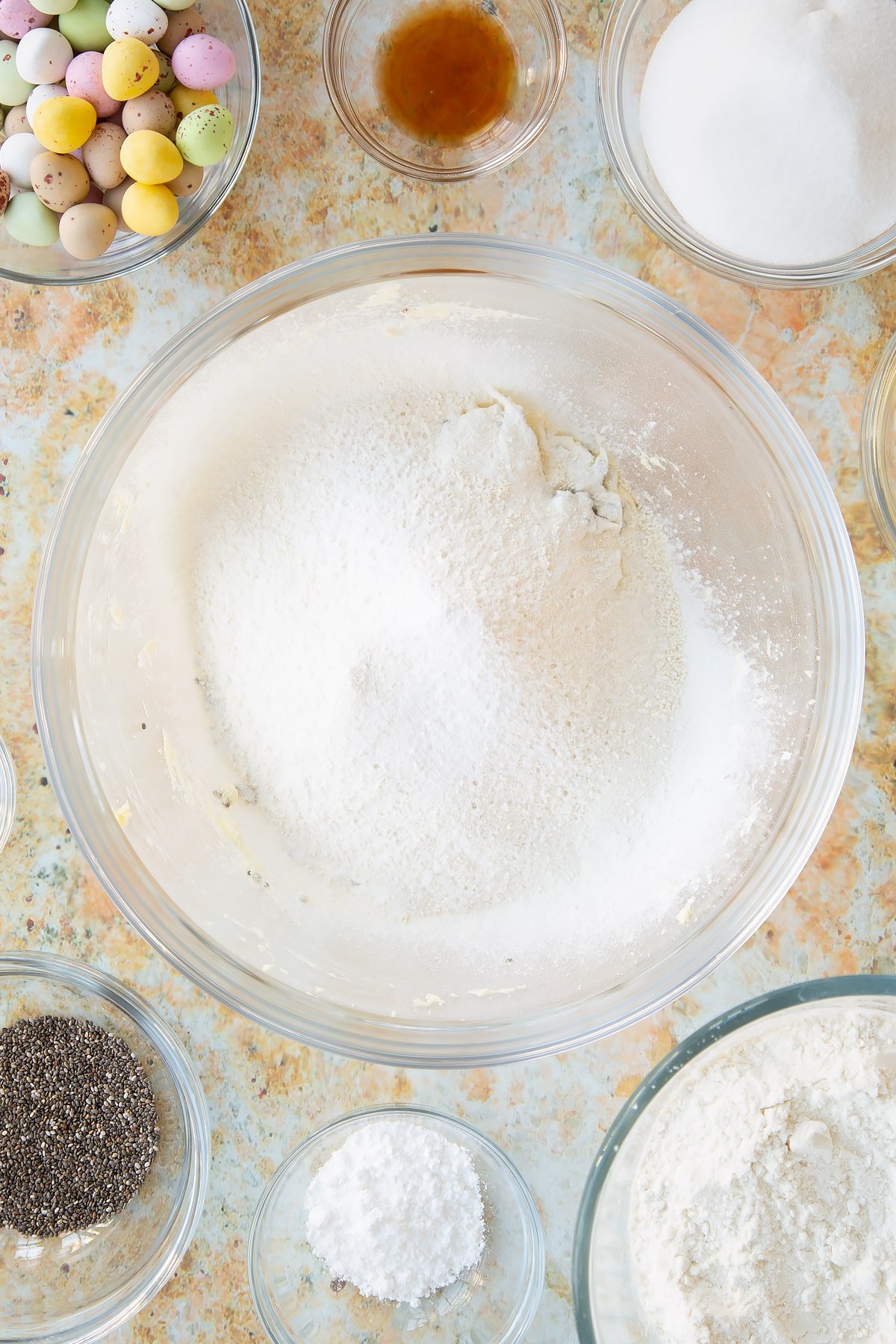 Sifting in the gluten free flour, baking powder, salt and bicarbonate of soda into the mixing bowl of ingredients.