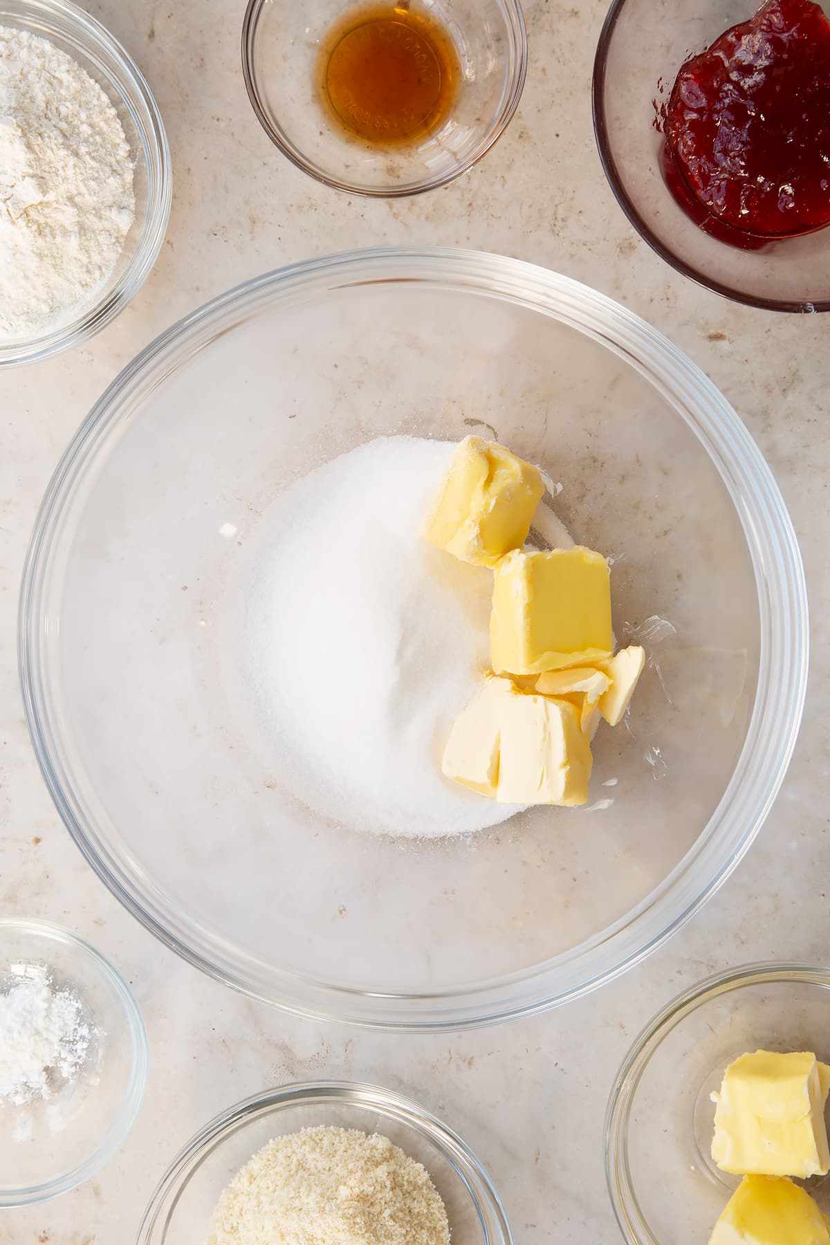 vegan butter and sugar in a large clear bowl surrounded by ingredients.