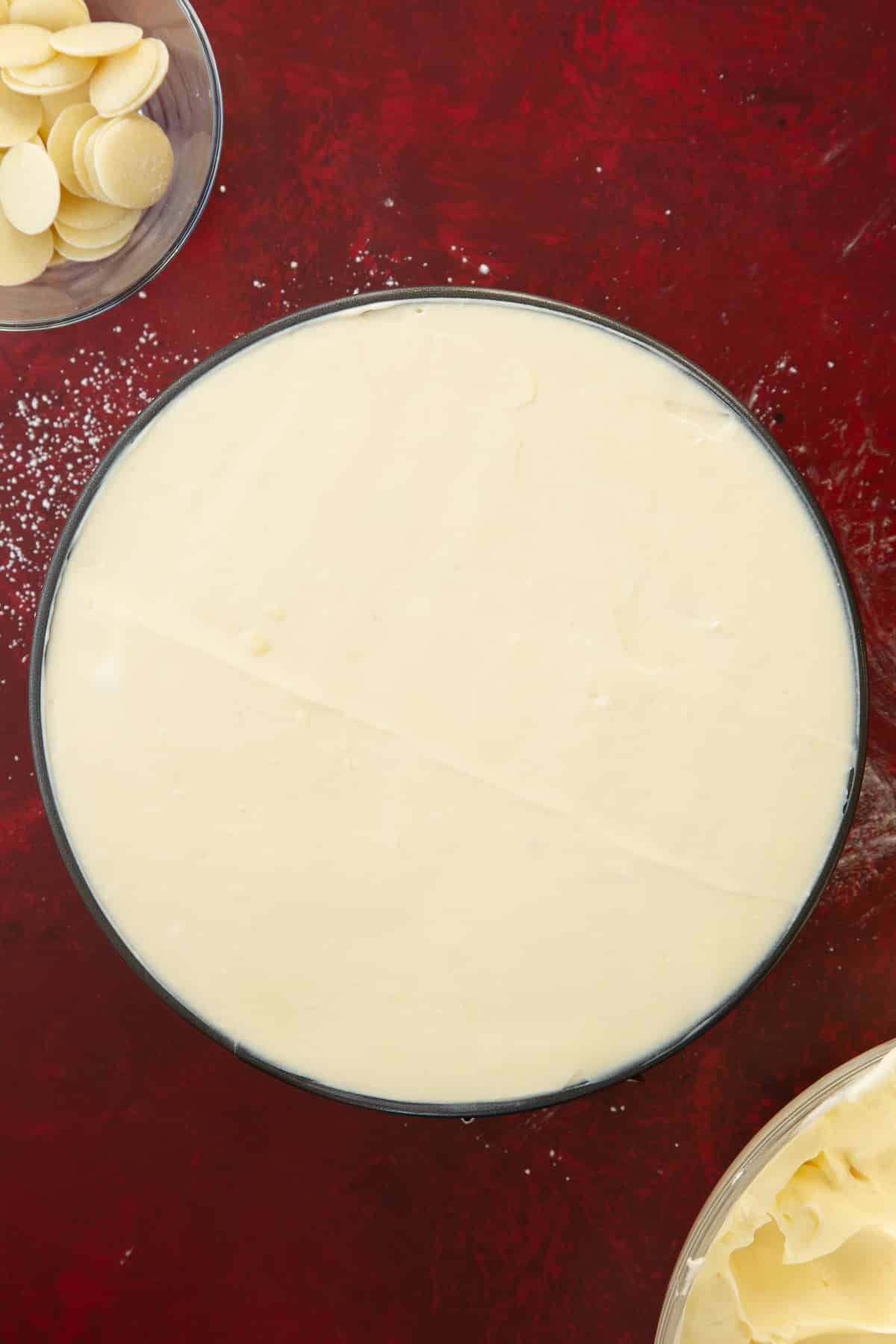 white chocolate cheesecake mixture in a round cake tin filled to the top. 