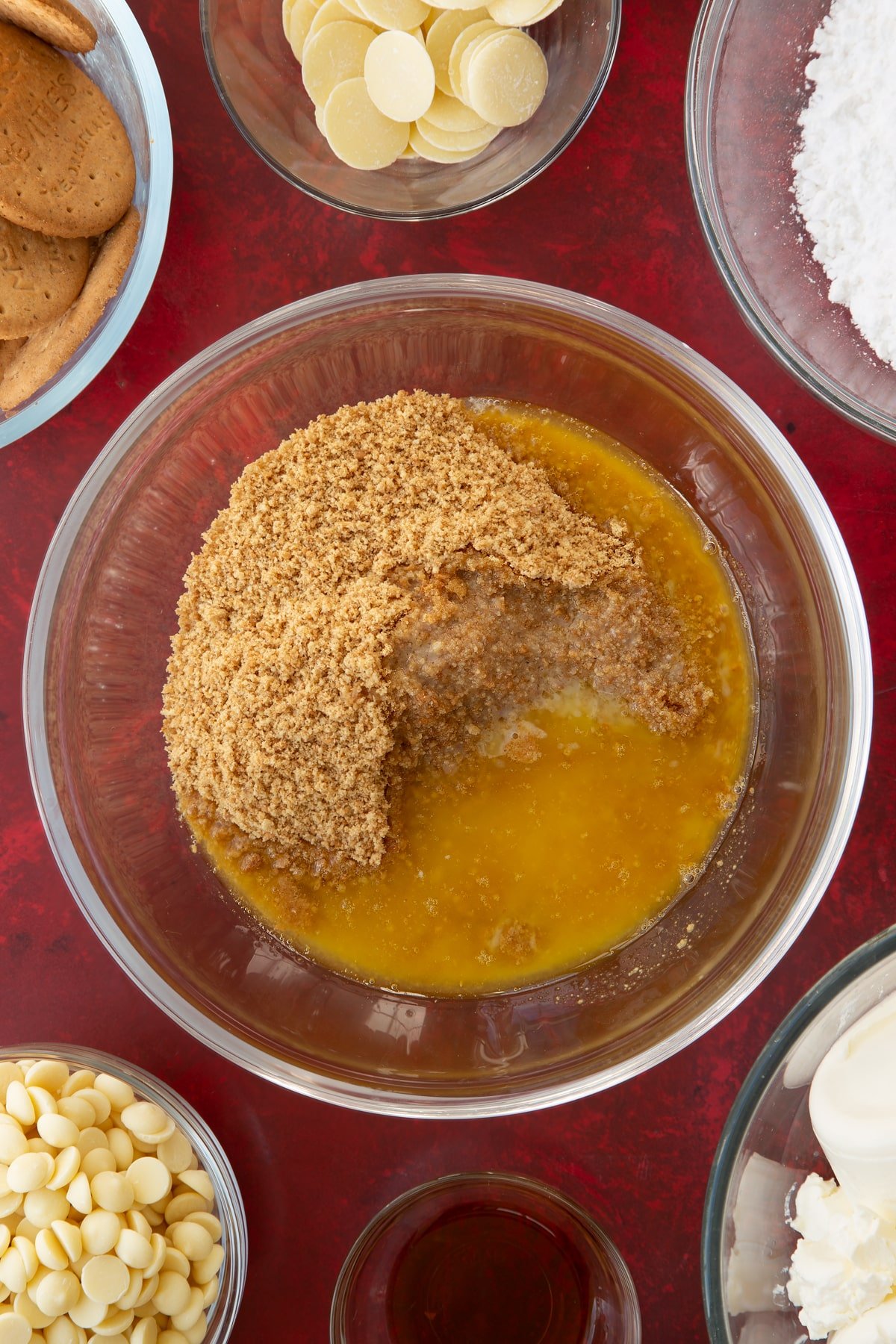 crushed biscuit crumbs in a large clear bowl topped with melted butter.