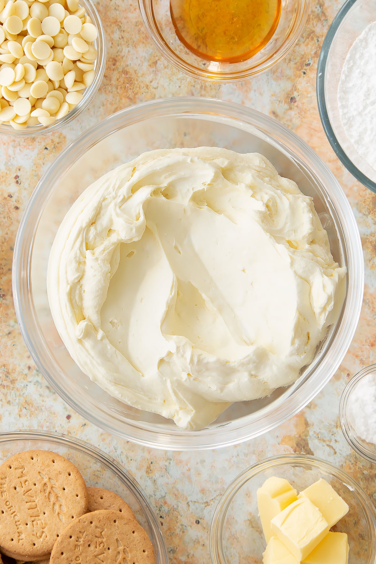 whisked cheese cake topping in a large clear bowl.