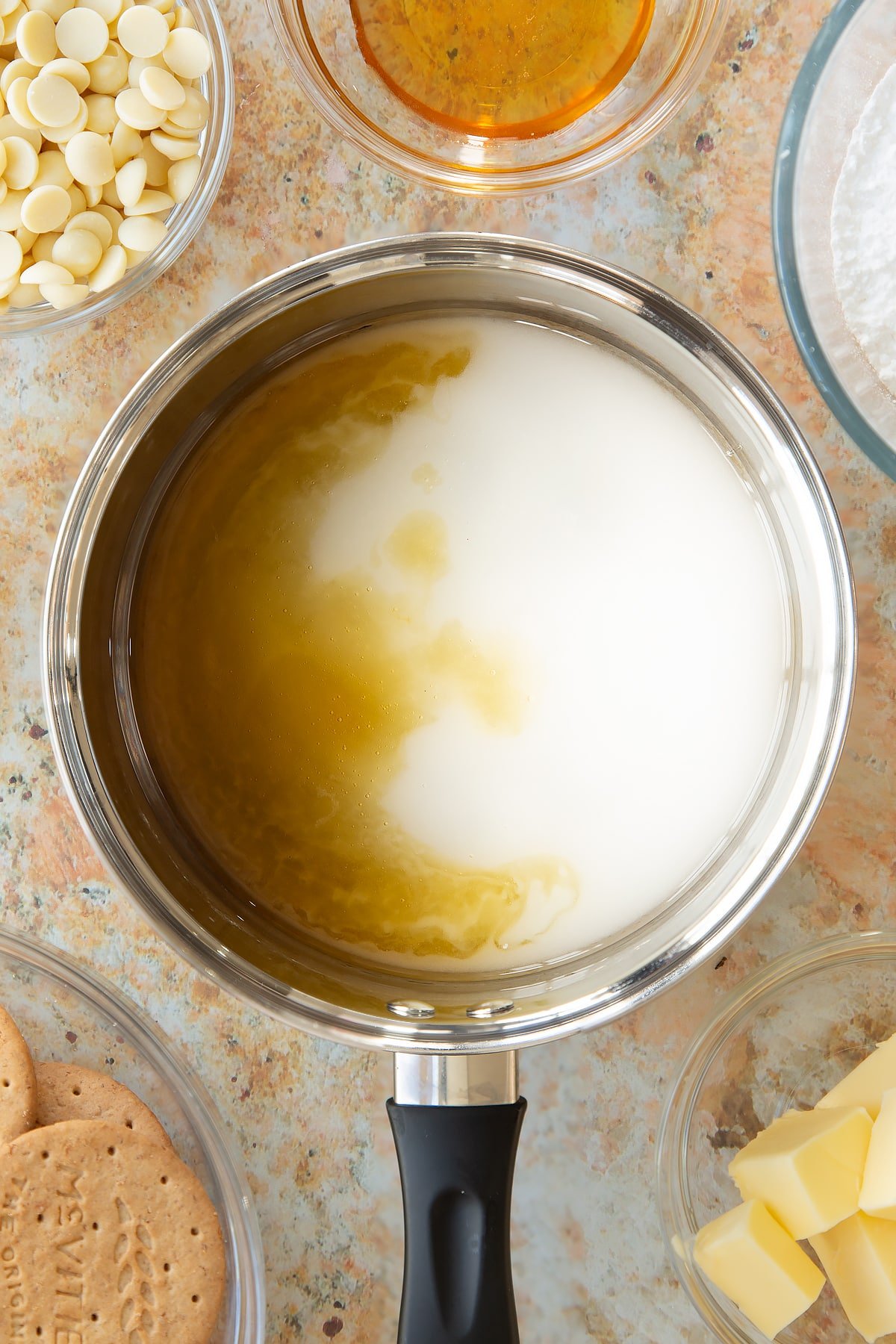 sugar, golden syrup and water in a large saucepan surrounded by bowls of ingredients.