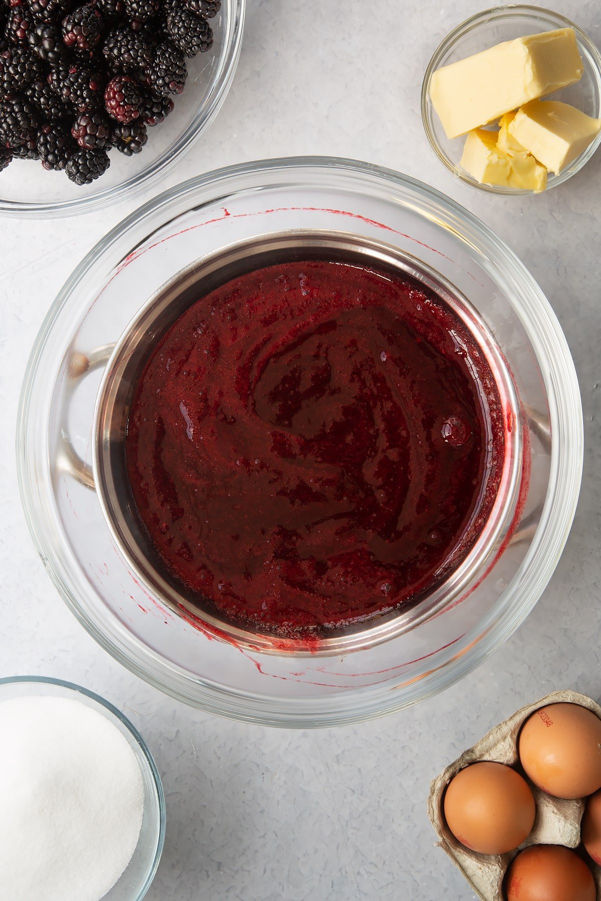 blackberry juice in a clear bowl over a heateded pan.