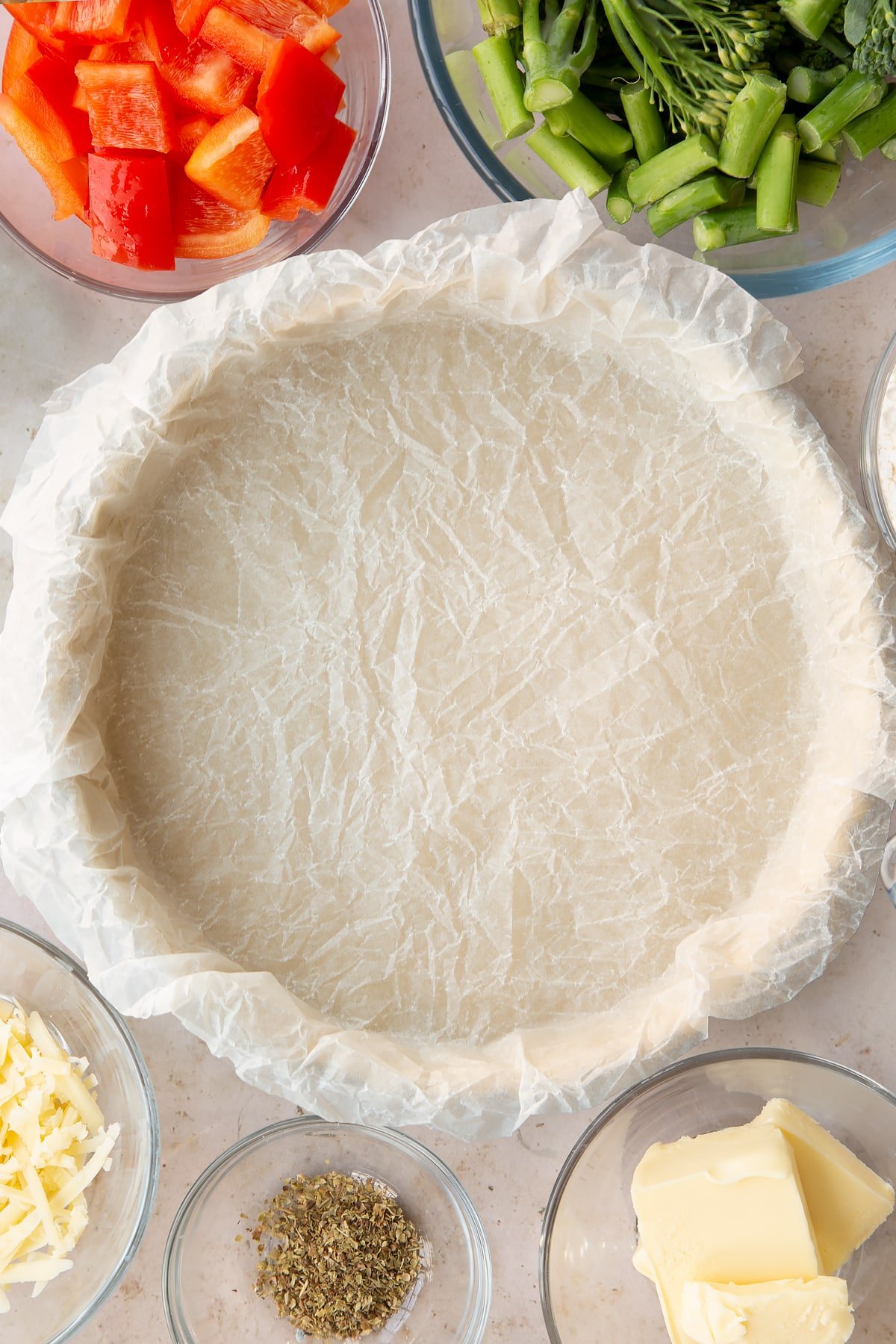 raw shortcrust pastry in a pastry dish covered with baking paper.