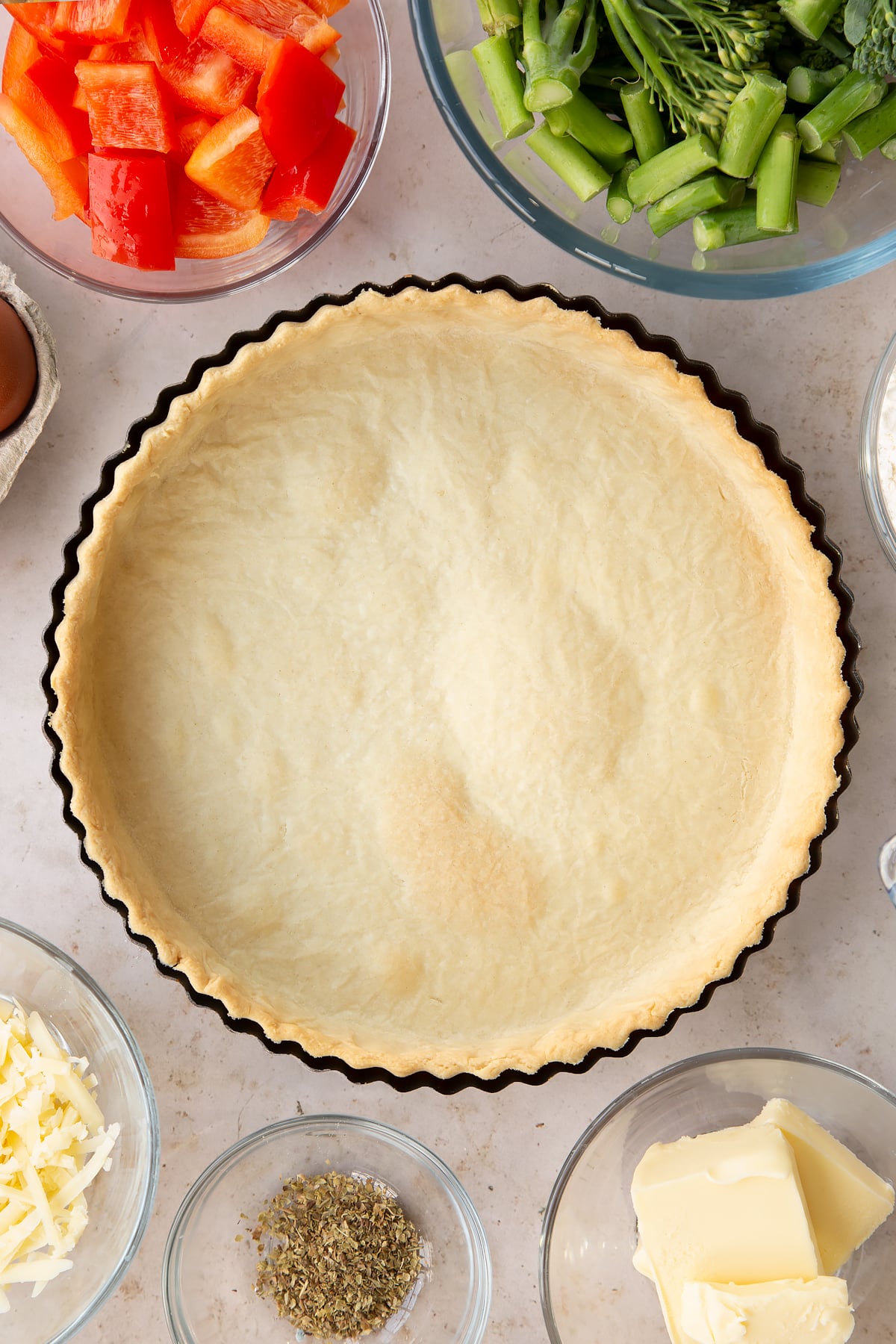 partially cooked shortcrust pastry in a pie dish with a bubbled base.