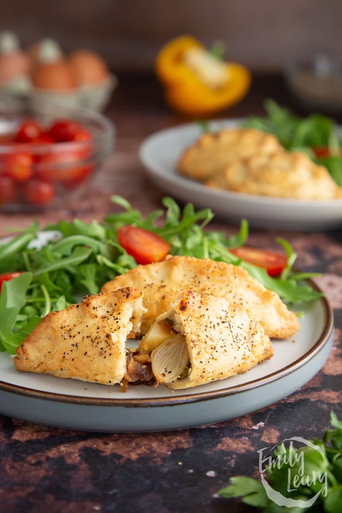 Finished mini cornish pasties served on a decorative plate with a side salad.