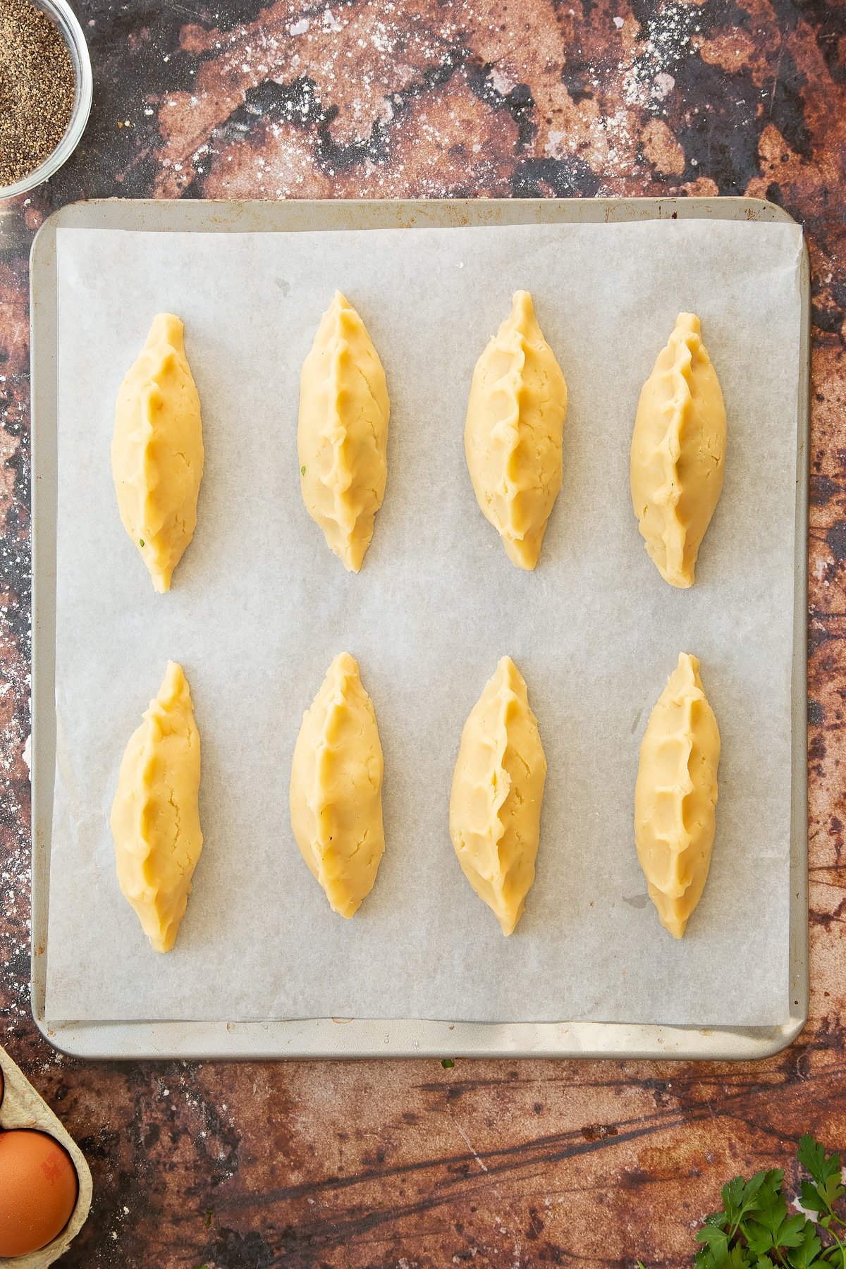 Overhead shot of the finished mini cornish pastries on a baking tray.