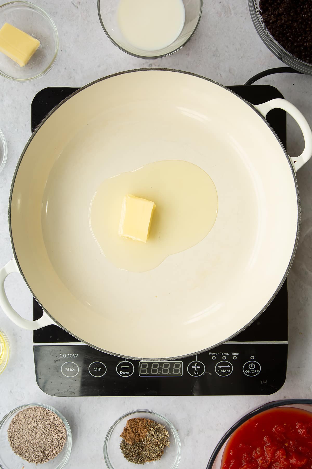 a large frying pan on induction hob with butter melting in the middle.