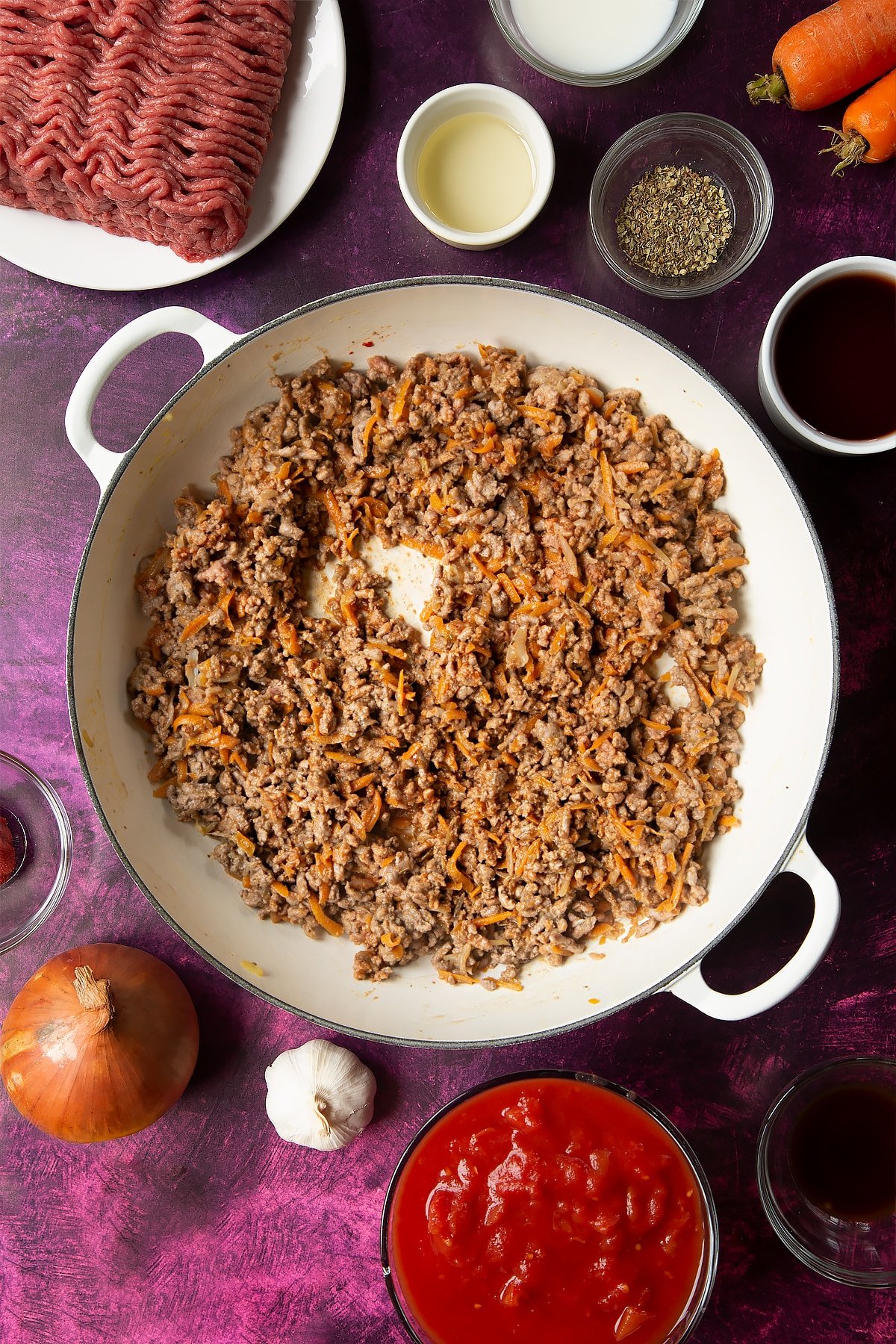 cooked carrot, onion and beef mince mix in a large white frying pan.