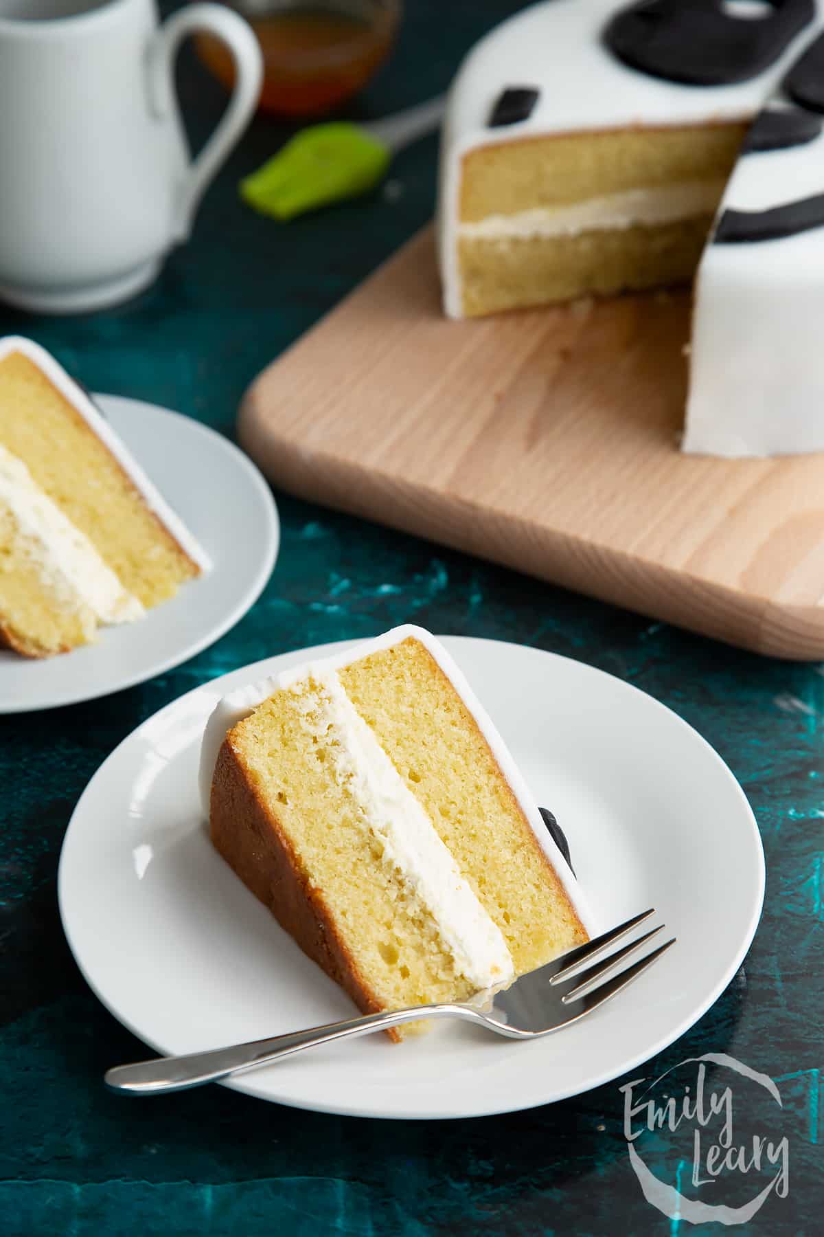 a slice of vanilla cake with buttercream on a white plate.