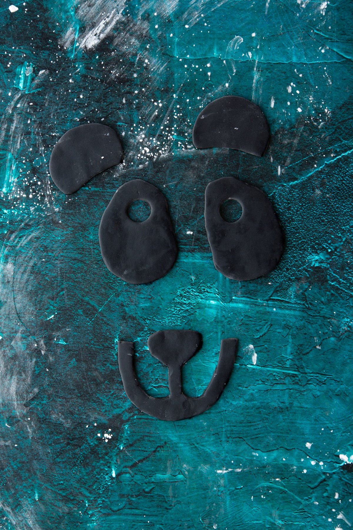 black royal icing panda features on a green marble background.