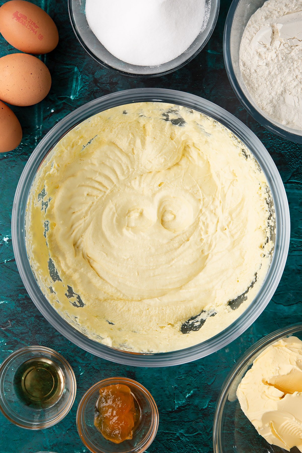 whisked cake batter in a large clear bowl.