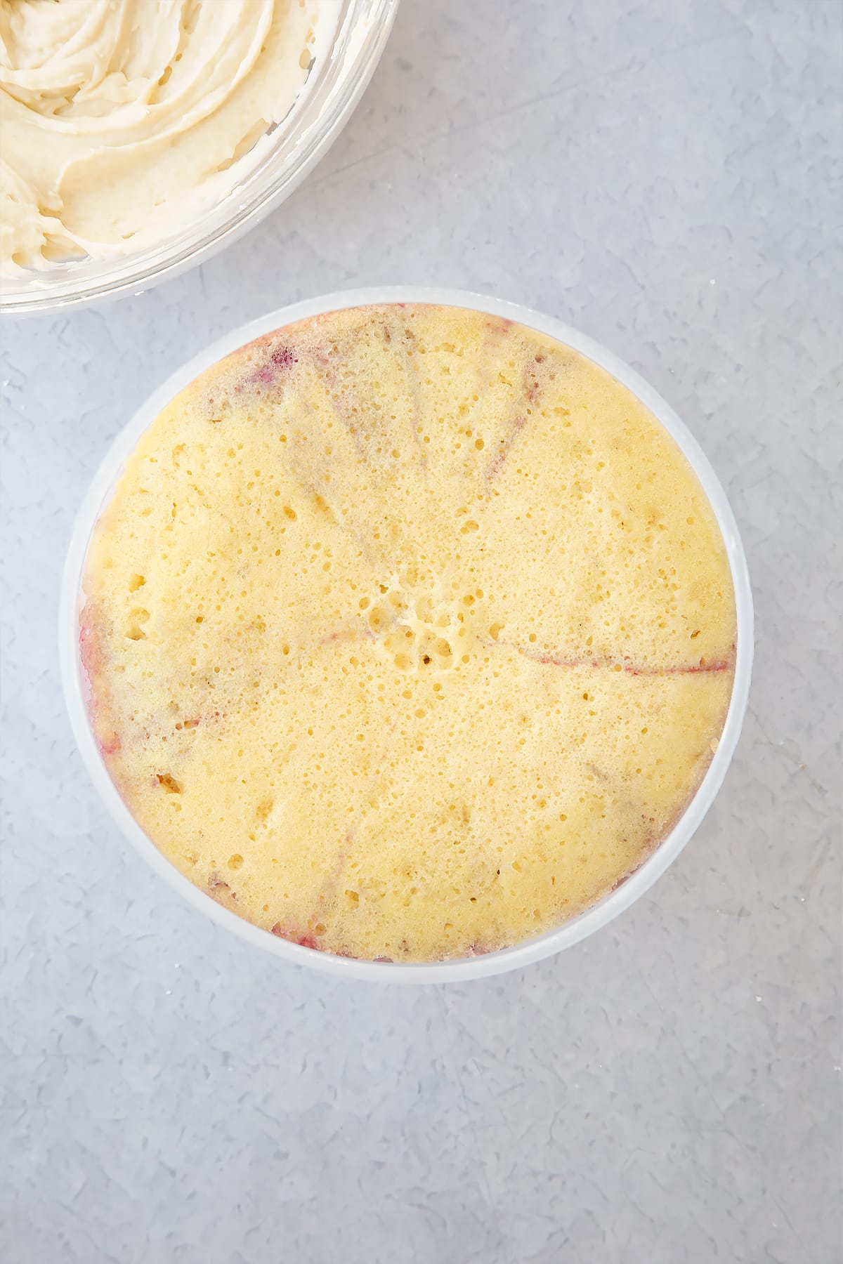 cooked summer fruit pudding in a pudding basin on a plain background.