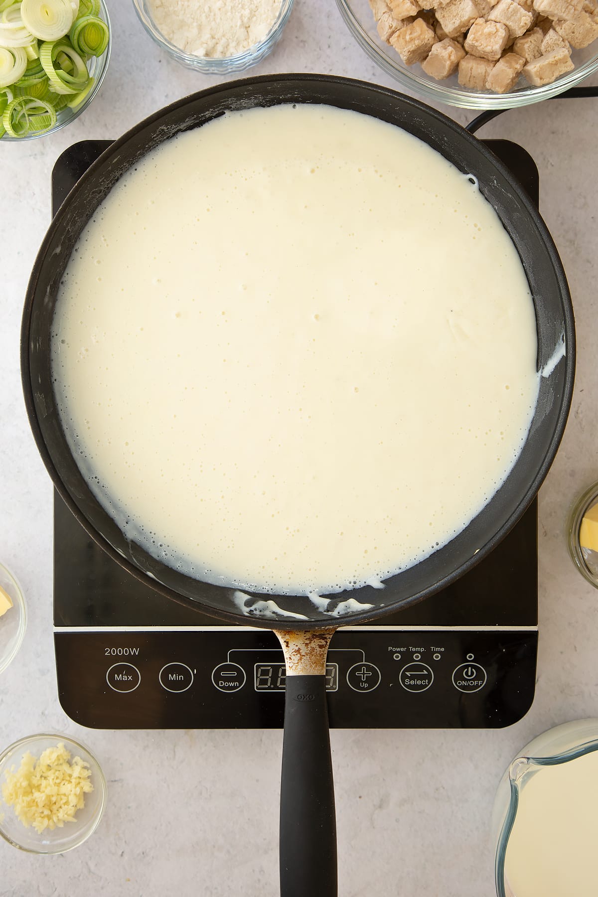 cooked milk and flour mix in a large frying pan on an induction hob.