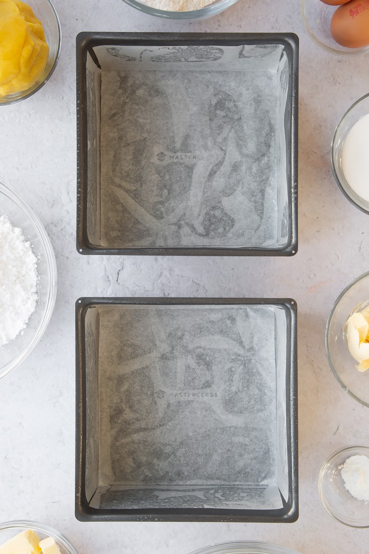 Overhead shot of two deep lined square baking tins.