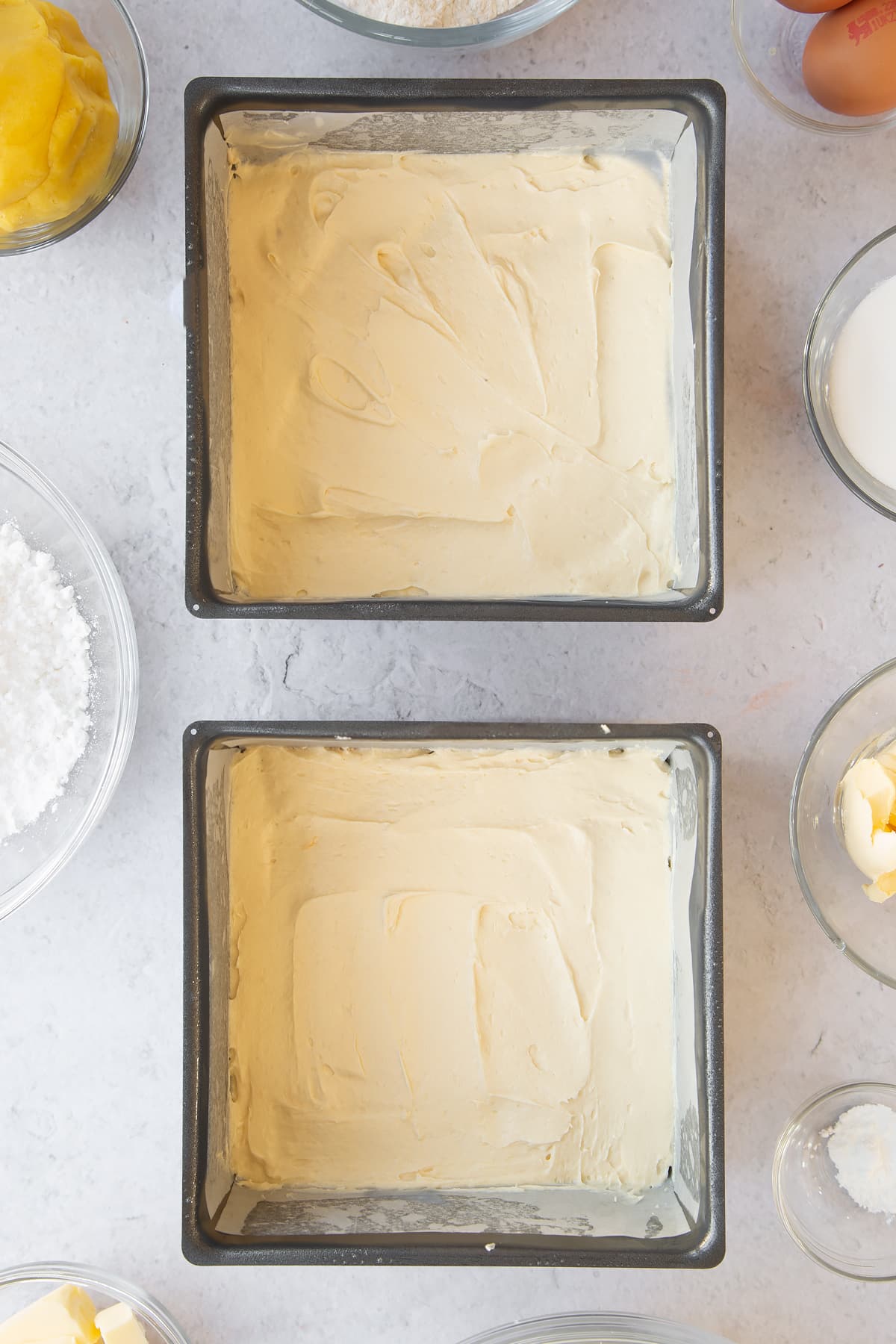 Overhead shot of the two square tins with equal amounts of batter in each.