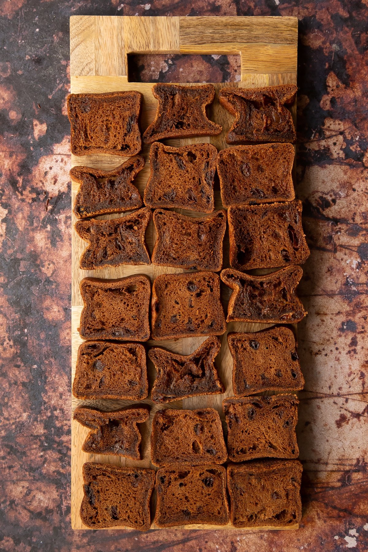 slices of malt loaf laid out on a wooden chopping board.