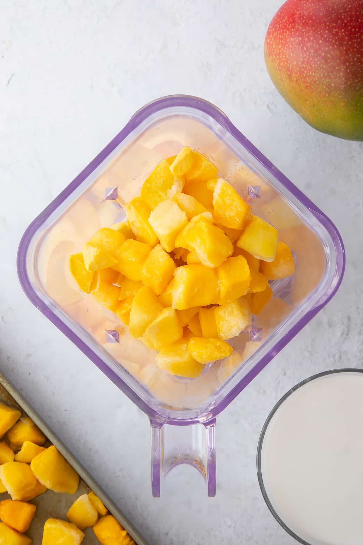 chunks of mango in a plastic blender cup.