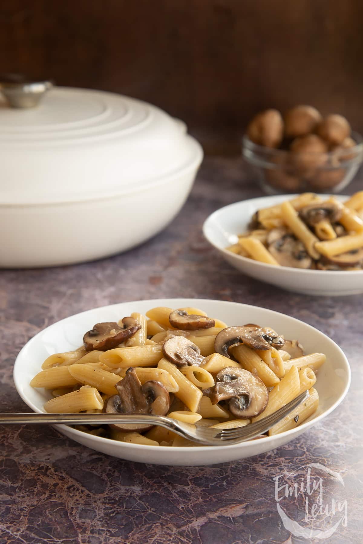 Miso mushroom pasta in a white pasta bowl with a fork tucked into the bowl.