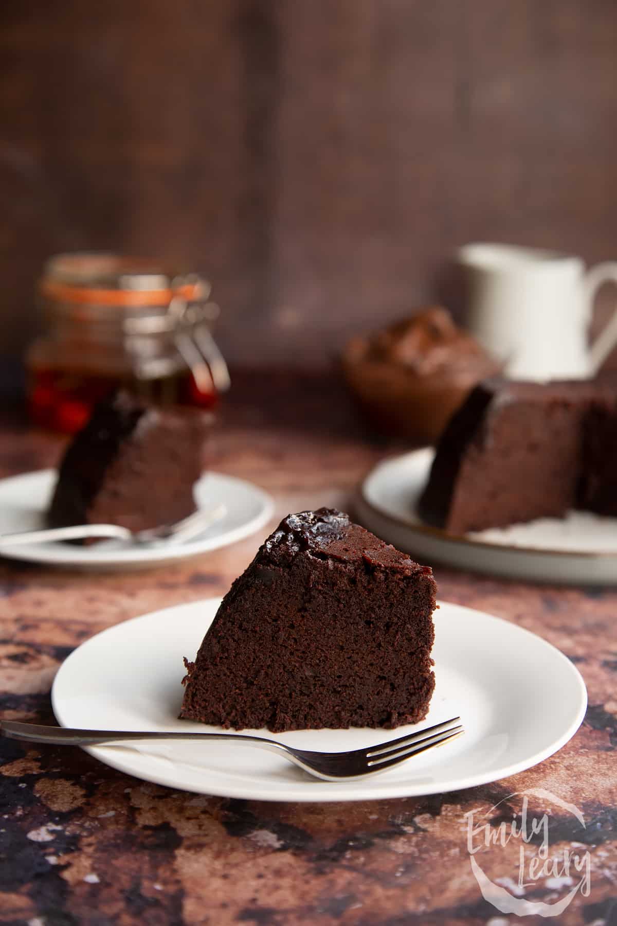 Nutella pudding cake slice on a white plate with a fork at the front.