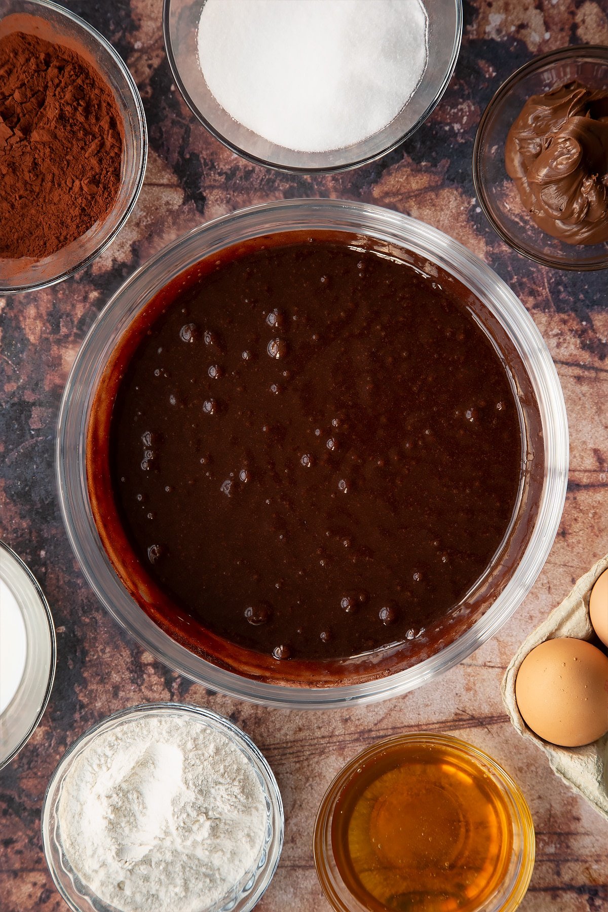 whisked chocolate batter in a large clear bowl.