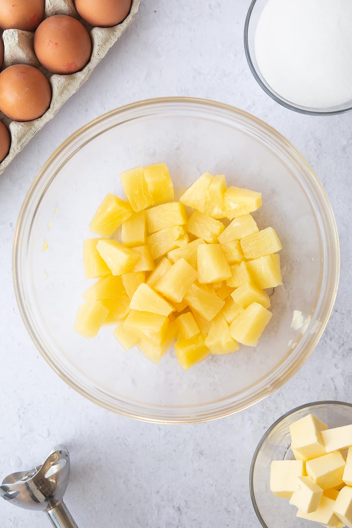 chunks of pineapple in a large clear bowl.