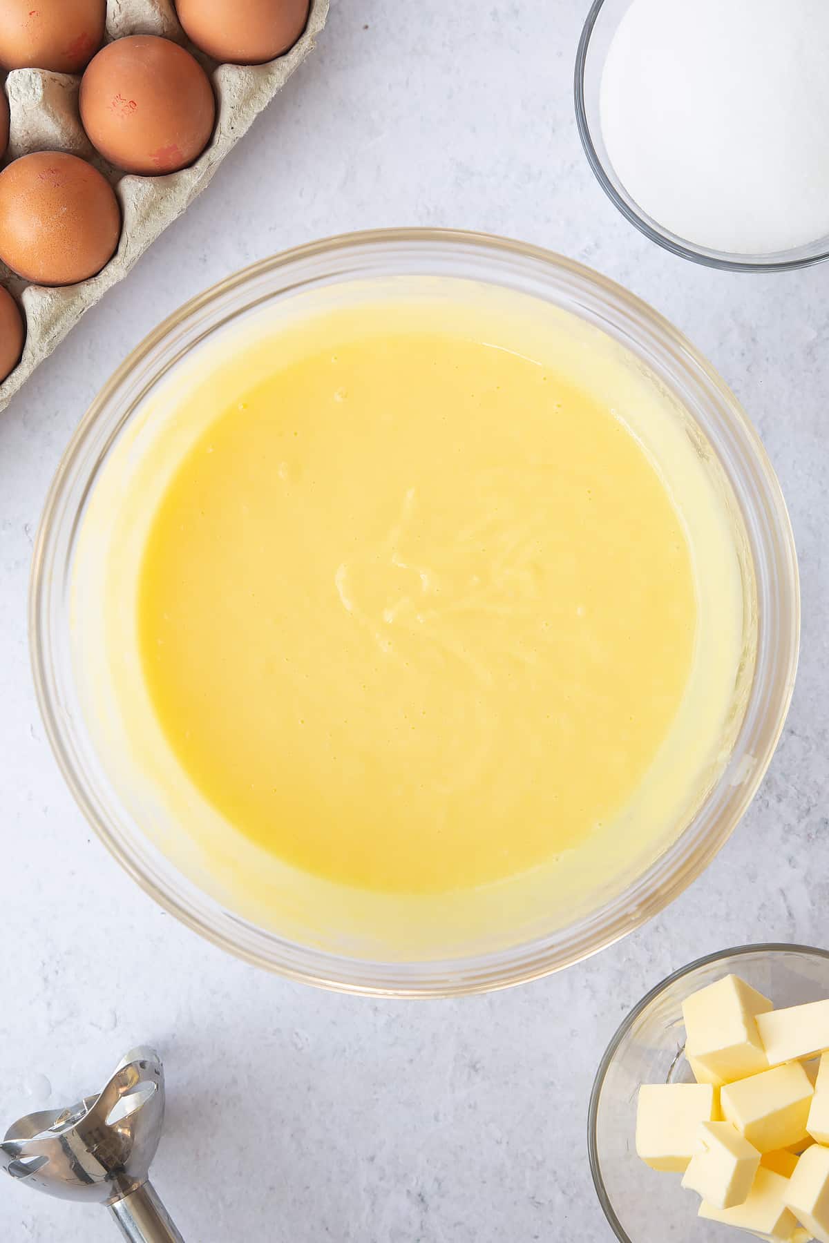 whisked pineapple curd mixture in a large clear bowl.