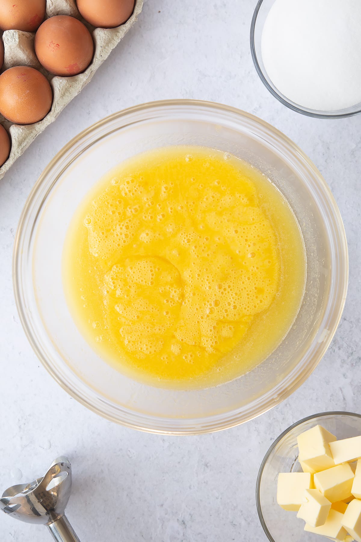 mixed pinapple mixture with eggs in a large clear bowl.