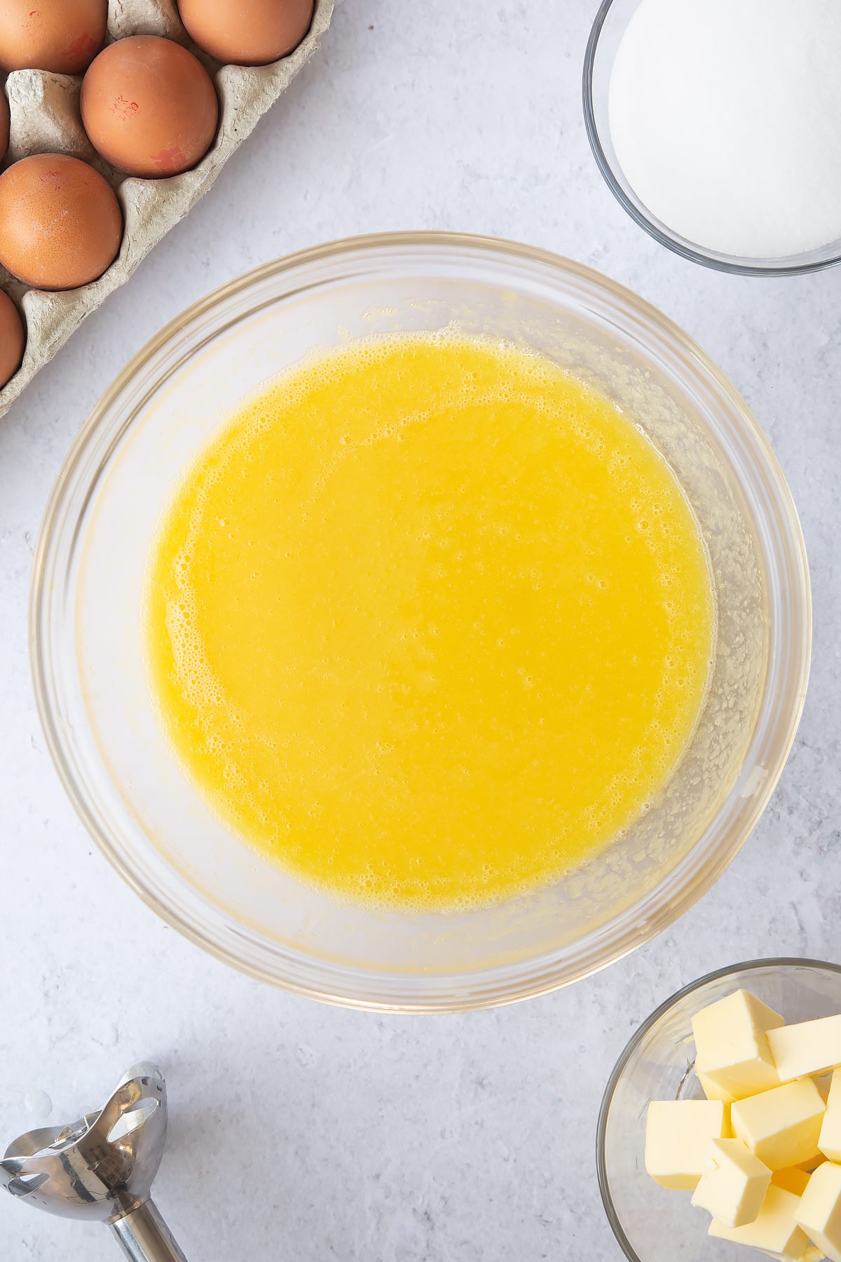 mixed pinapple mixture with eggs in a large clear bowl.