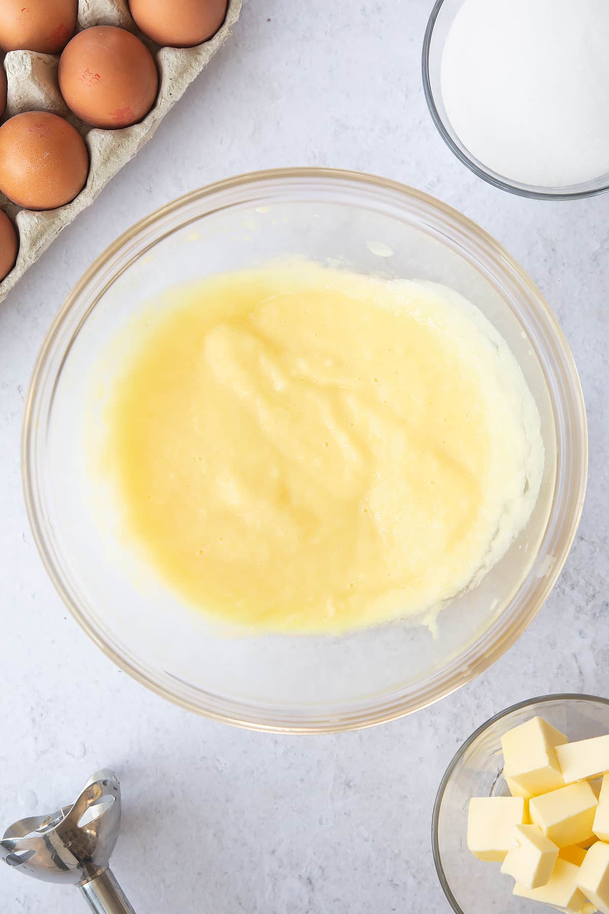 puree'd pineapple in a large clear bowl surrounded by ingredients.